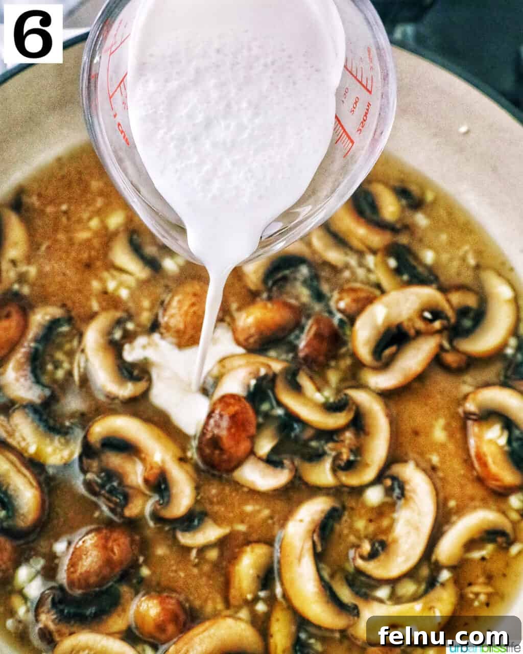 Earthy Mushroom Pesto Pasta 11 Pouring heavy cream into the mushroom and broth mixture in a pan.
