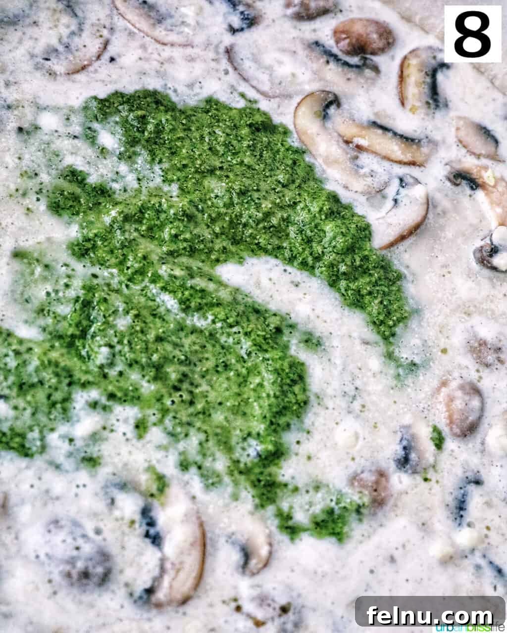 Earthy Mushroom Pesto Pasta 13 Adding pesto sauce to the creamy mushroom mixture in a pan, ready to be stirred.