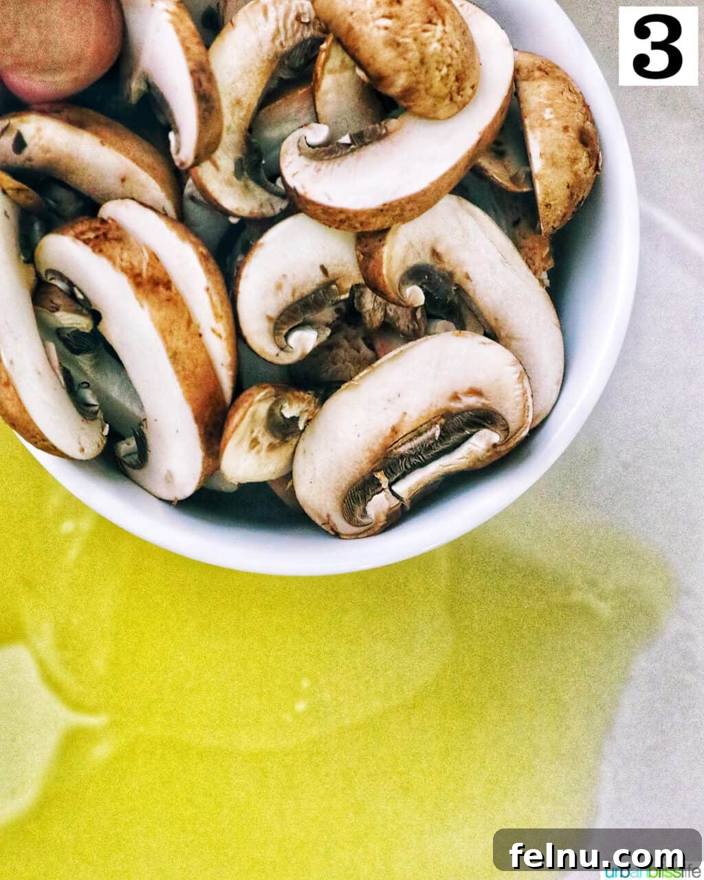 Earthy Mushroom Pesto Pasta 7 Sliced mushrooms being added to hot olive oil in a pan, ready to cook.