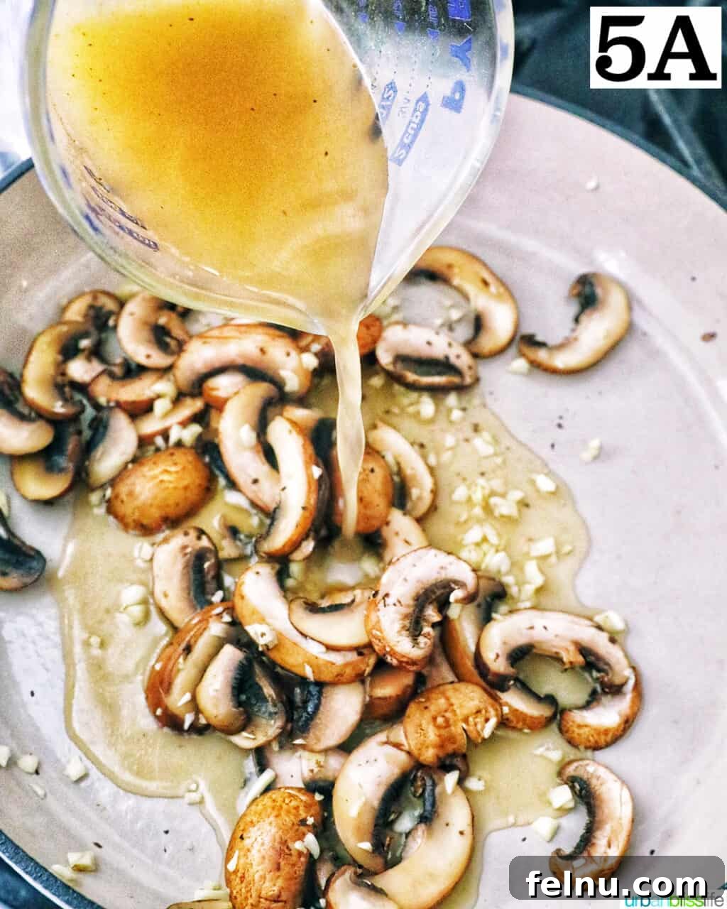 Earthy Mushroom Pesto Pasta 9 Pouring vegetable broth over sautéed mushrooms and garlic in a pan.
