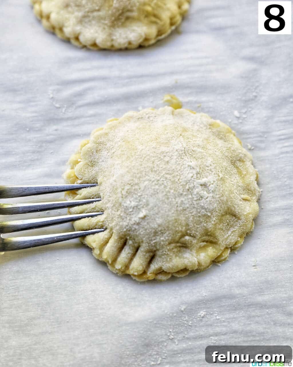 Sun-Kissed Peach Mango Pie 12 A fork pressing into the sides of a peach mango pie, crimping the edges for a seal.