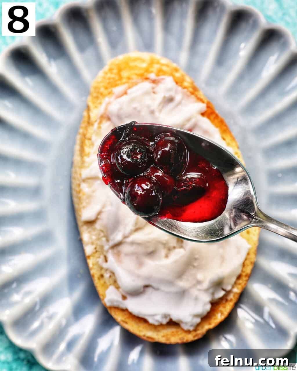 Blueberry Bliss Toast 11 Spoonfuls of rich blueberry compote being dolloped over cream cheese-covered toast.