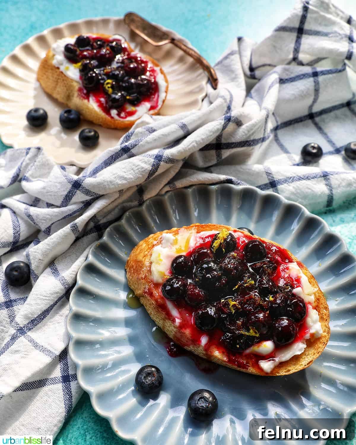 Blueberry Bliss Toast 14 Two plates of blueberry and cream cheese toast, one on a blue scalloped plate and another slightly blurred in the background.