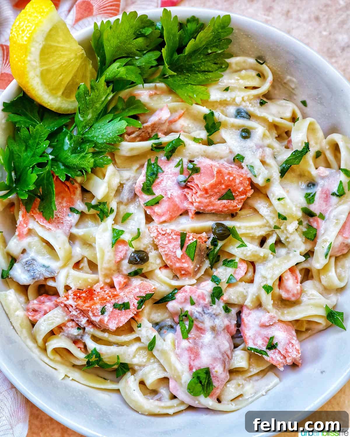 Velvety Salmon Pasta 2 A beautifully plated Pasta Alla Salmone, garnished with fresh lemon wedges and vibrant parsley, presented in a crisp white bowl.