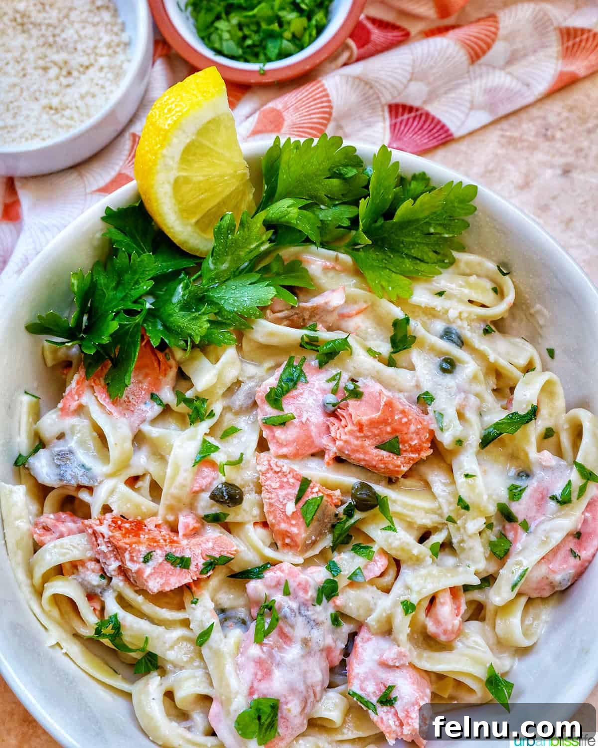 Velvety Salmon Pasta 19 A pristine white bowl filled with creamy pasta alla salmone, artfully garnished with fresh parsley and bright lemon slices.