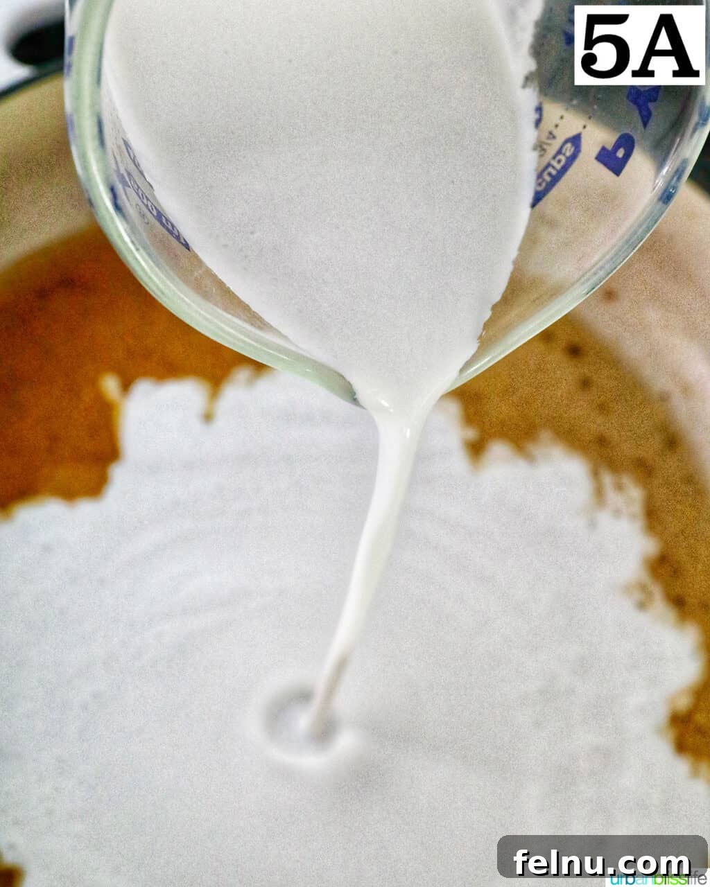 Velvety Salmon Pasta 10 Rich heavy cream being poured into a pan, forming the base of the luxurious sauce.