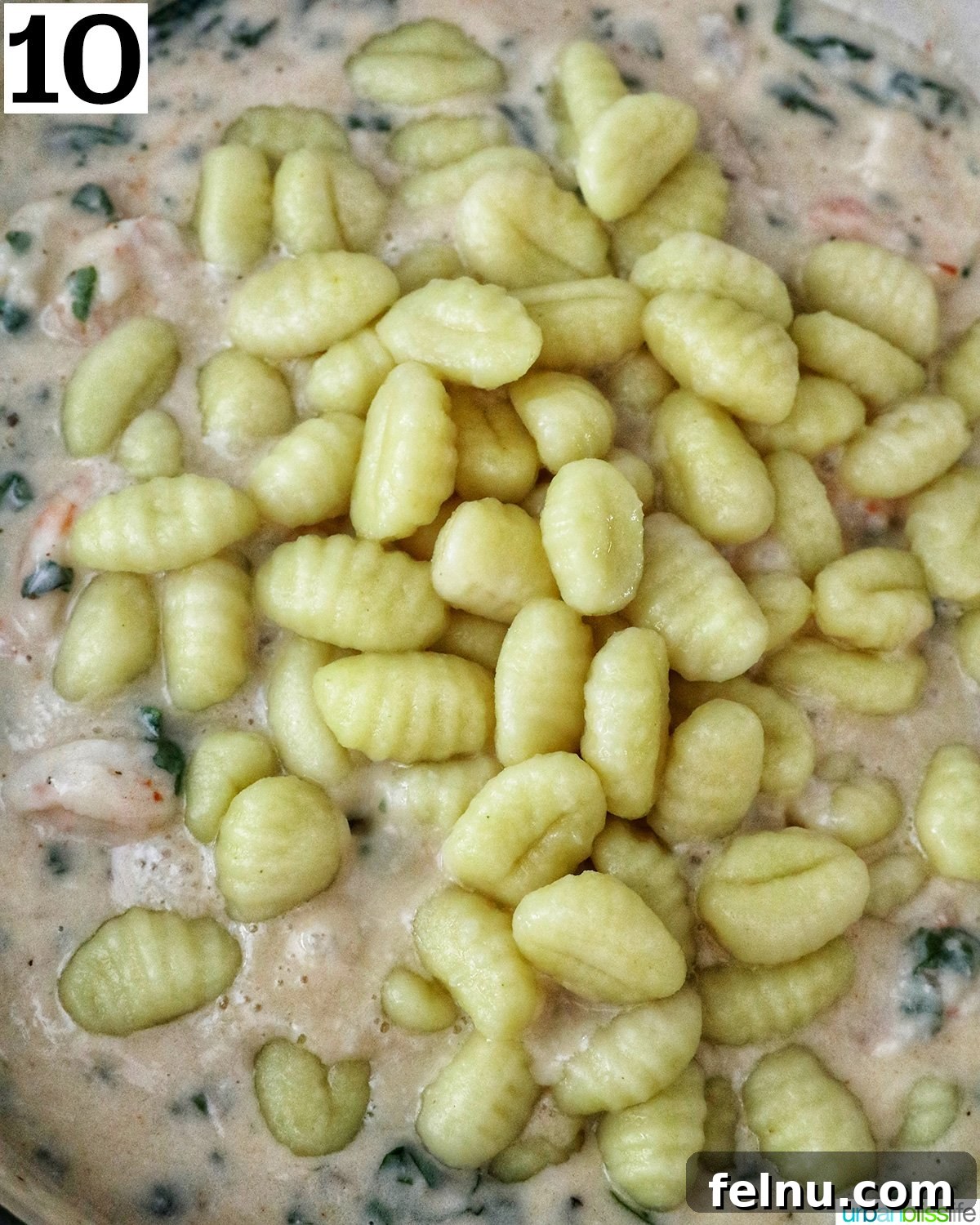 Tuscan Shrimp Gnocchi Delight 15 Cooked gnocchi being added to the sauce.