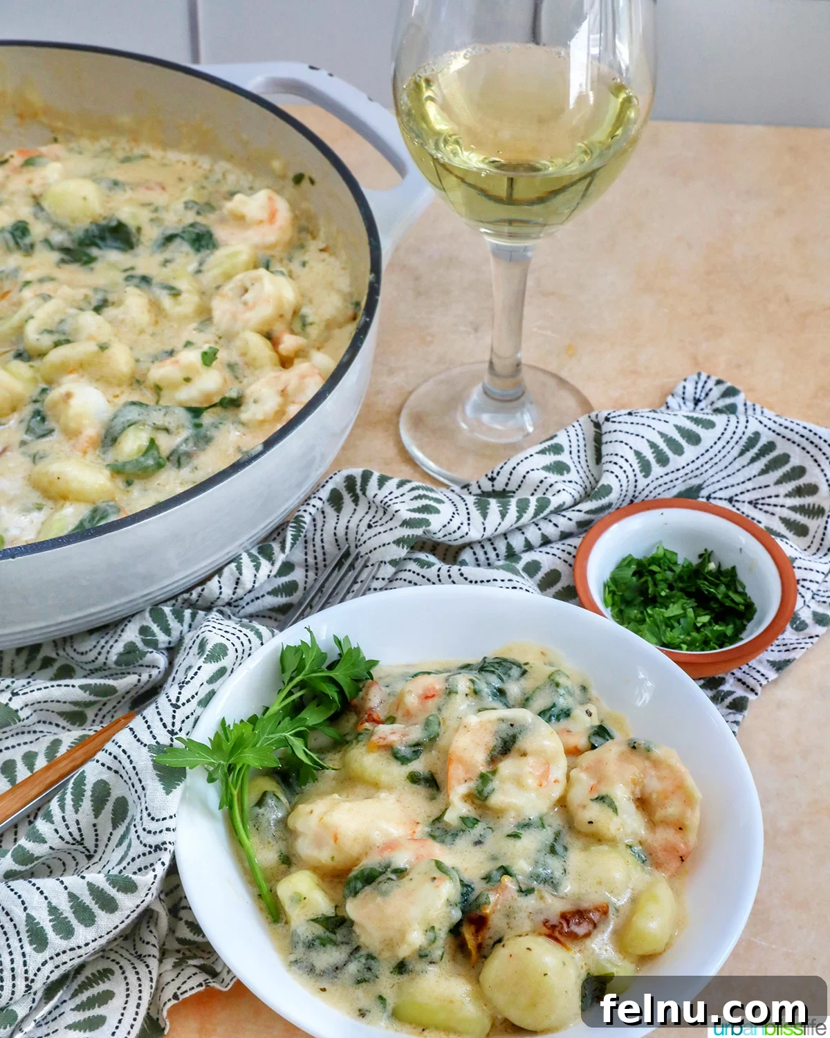 Tuscan Shrimp Gnocchi Delight 18 Wine glass next to a bowl of Tuscan Shrimp Gnocchi.