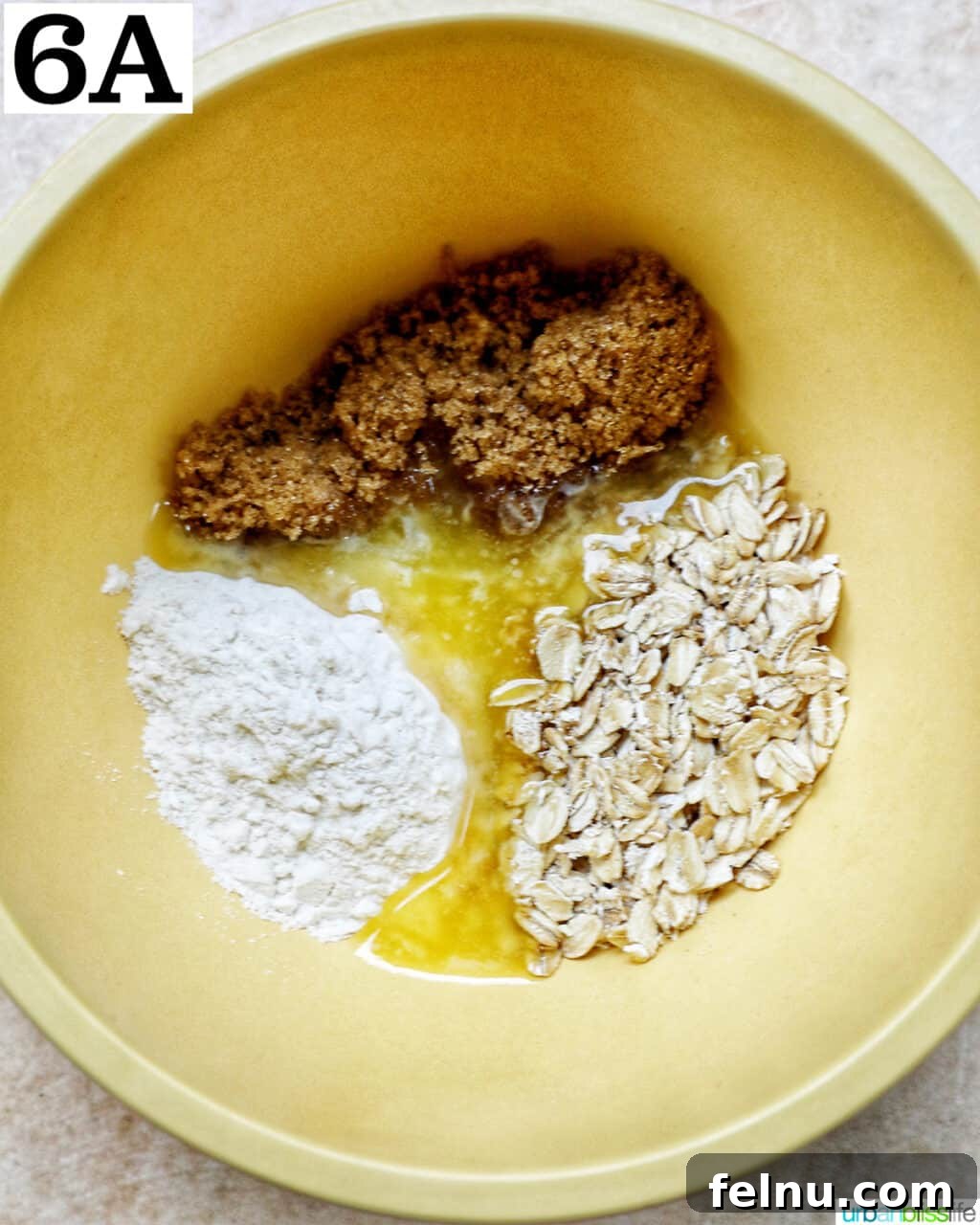Air Fryer Apple Crumble 11 Yellow bowl with oats, sugar, and flour to make a streusel topping.