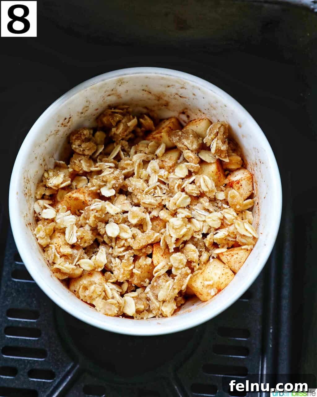 Air Fryer Apple Crumble 14 Bowl of Air Fryer Apple Crisp in an air fryer basket.