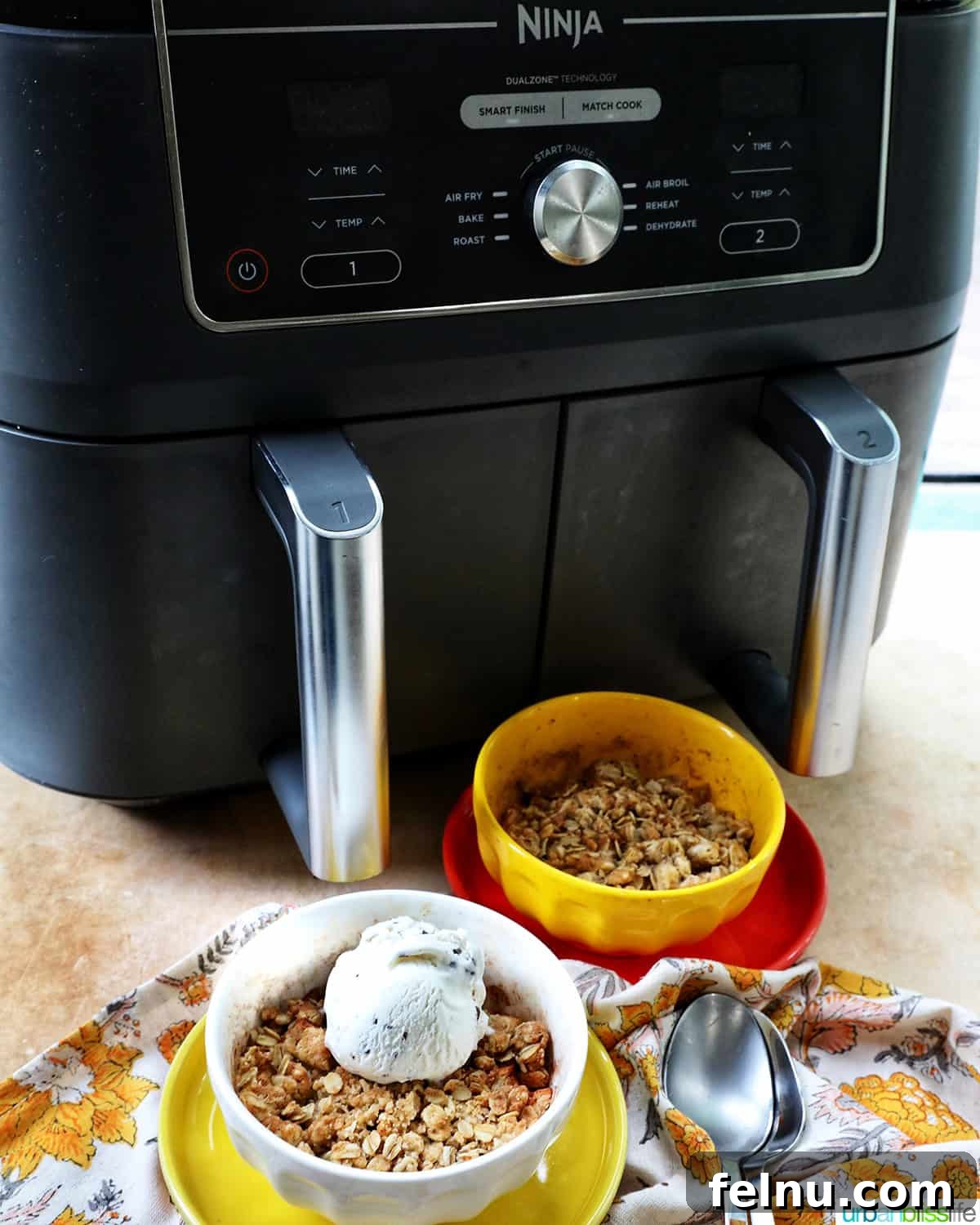 Air Fryer Apple Crumble 17 Ninja Air Fryer with two bowls of Air Fryer Apple Crisp and spoons.