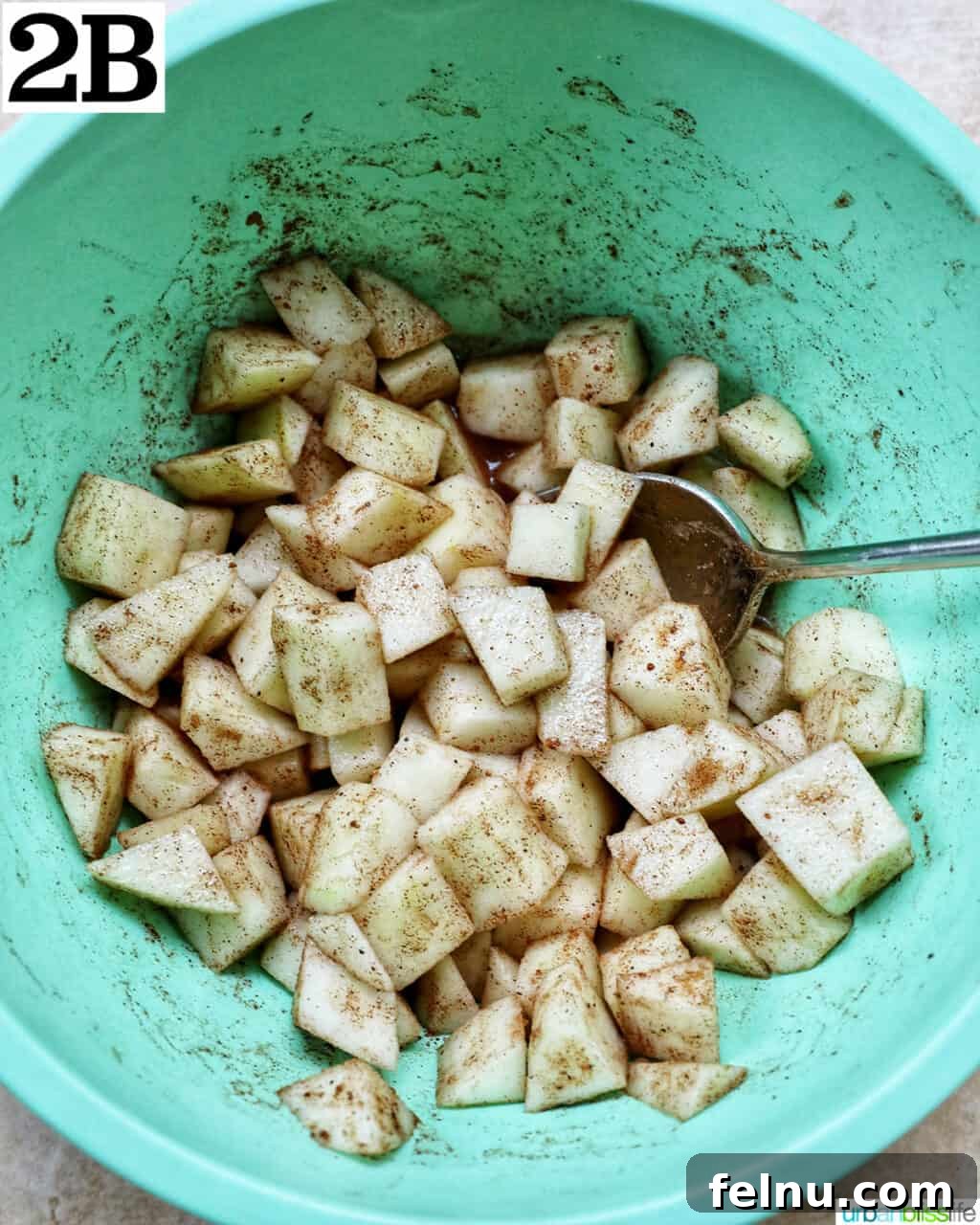 Air Fryer Apple Crumble 7 Green bowl with diced apples and spices.