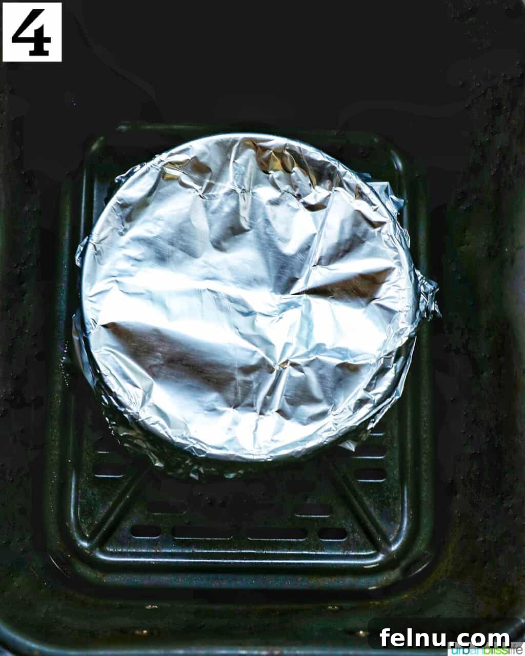Air Fryer Apple Crumble 9 Bowl wrapped in aluminum foil in an air fryer basket.