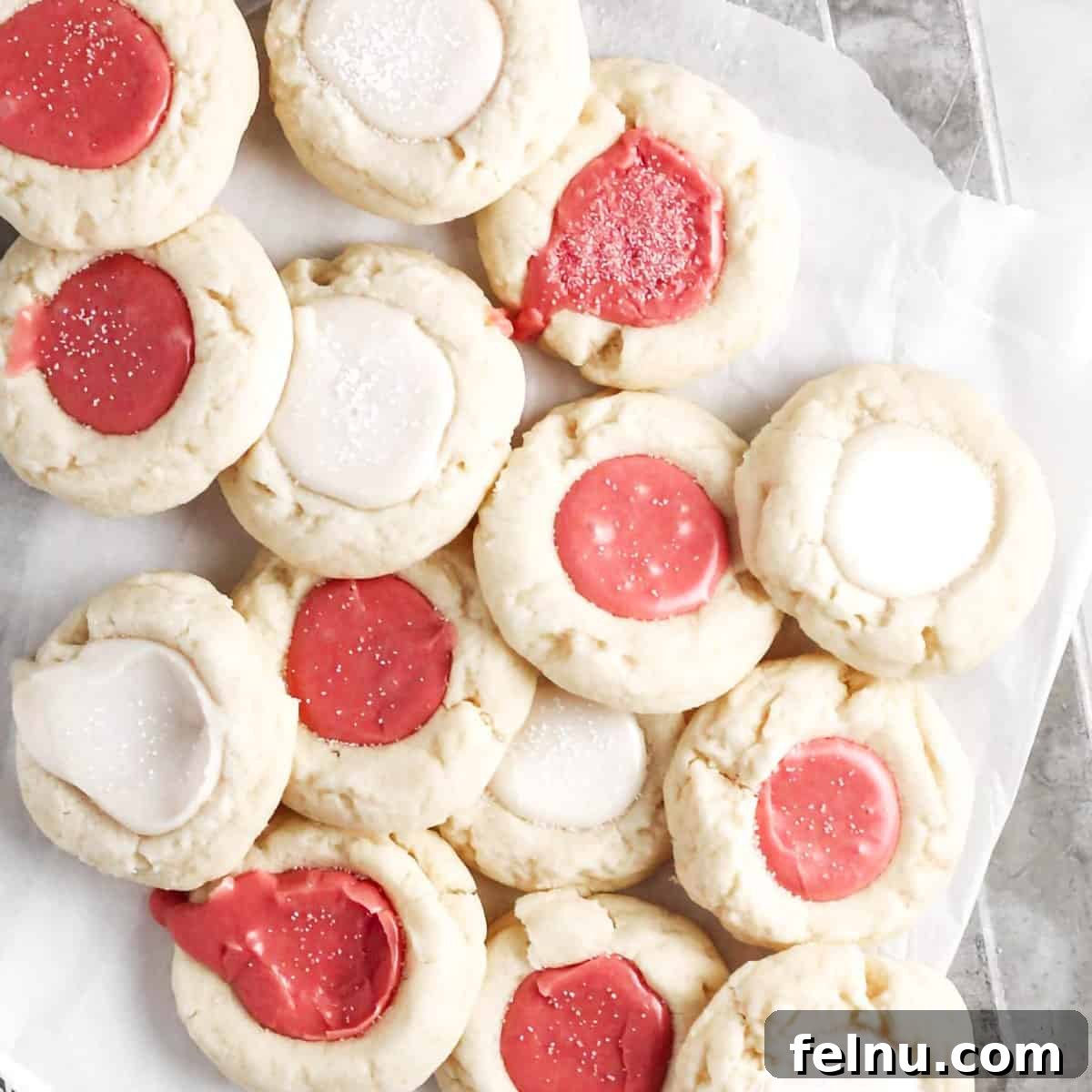 Thumbprint cookies with festive icing on a tray.