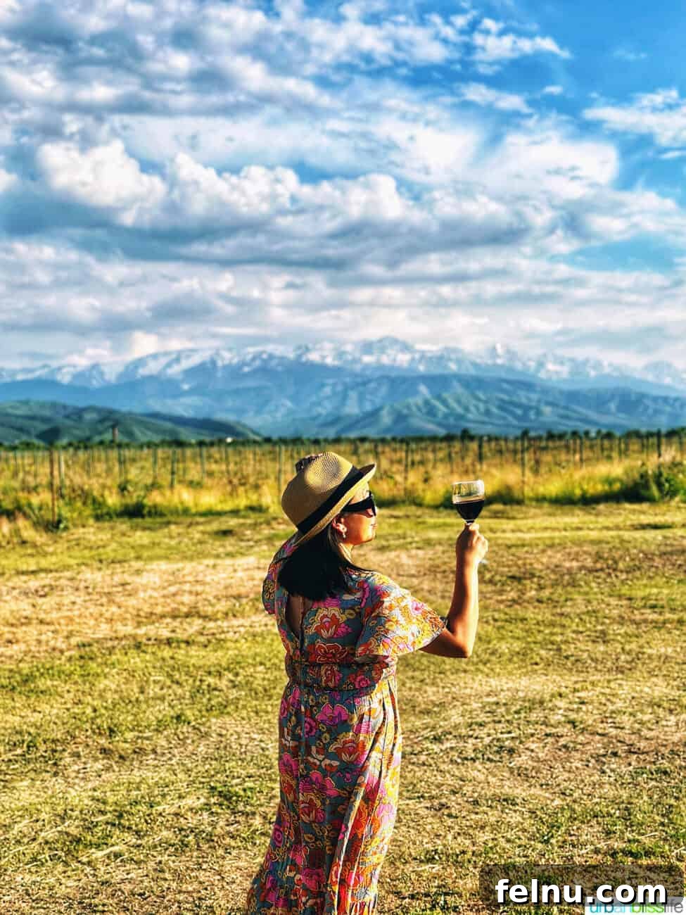 Kazakhstan Wine: A Journey Through Time and Taste 8 Marlynn Jayme Schotland holding a glass of Kazakhstan wine at Arba Winery with the Tian Shan mountains in the background.