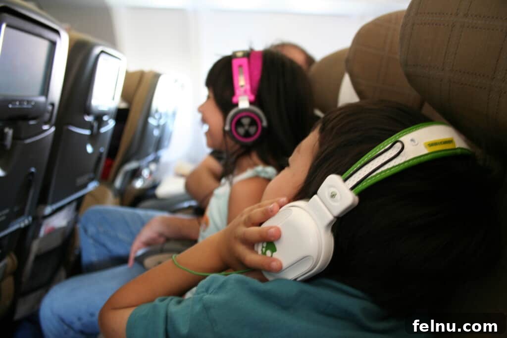 Smooth Travels for Tiny Globetrotters 12 Tips for Long-Haul Flights 6 daughter and son on a plane watching tv