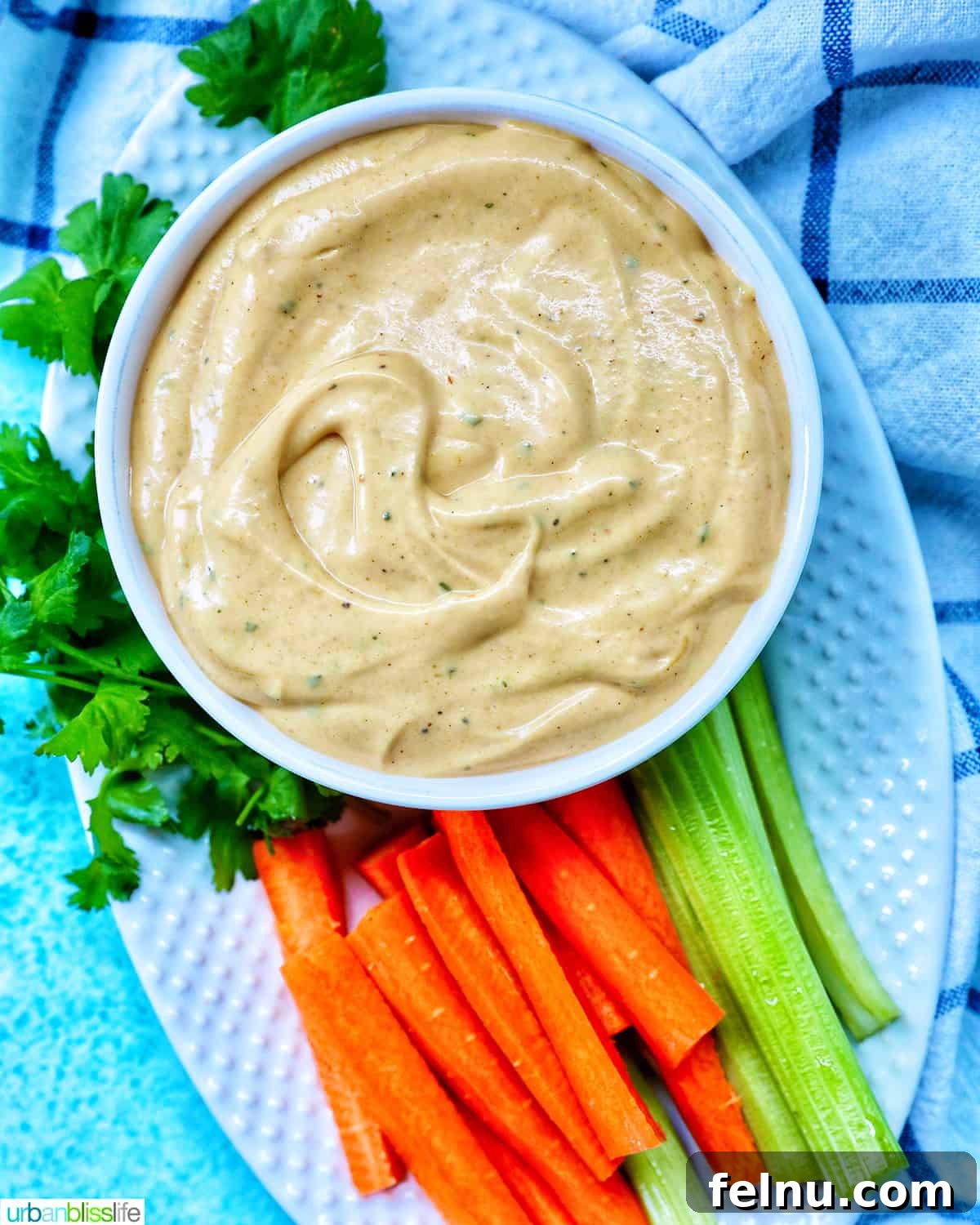 Bowl of Buffalo Ranch Sauce with carrot and celery sticks.