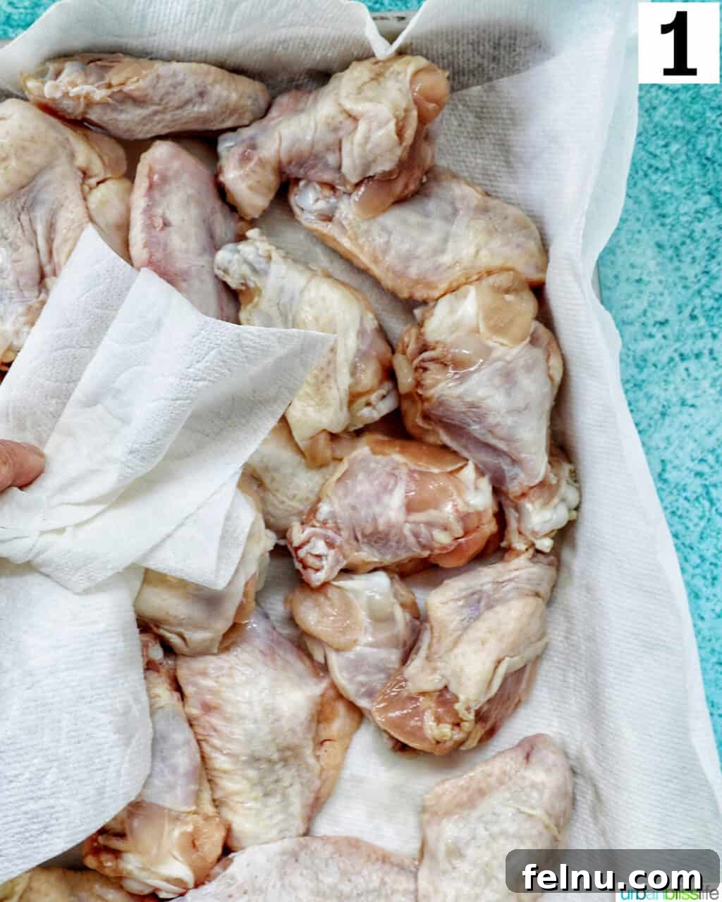 Ultimate Crispy Salt and Pepper Wings 5 dabbing raw chicken wings with a paper towel to dry before baking.