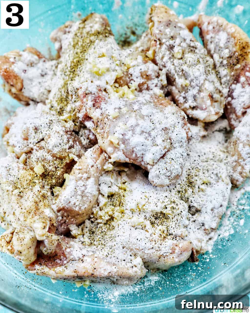 Ultimate Crispy Salt and Pepper Wings 7 seasoned chicken wings in a large glass bowl.