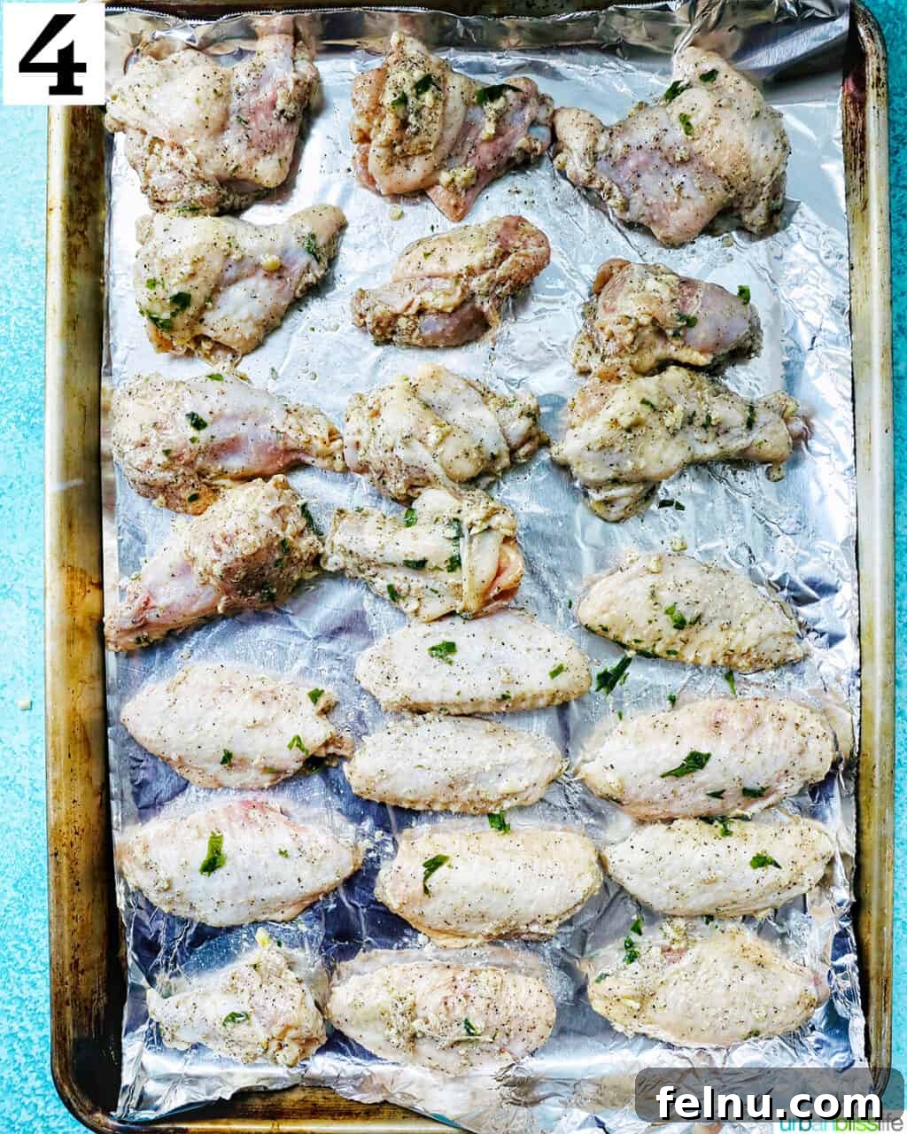 Ultimate Crispy Salt and Pepper Wings 8 chicken wings in rows on aluminum foil on a baking sheet.