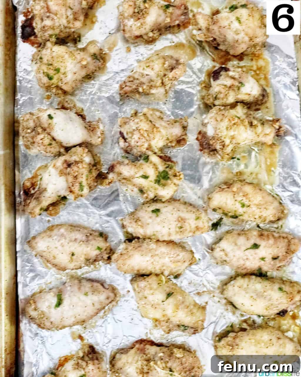 Ultimate Crispy Salt and Pepper Wings 10 chicken wings in rows on aluminum foil on a baking sheet.