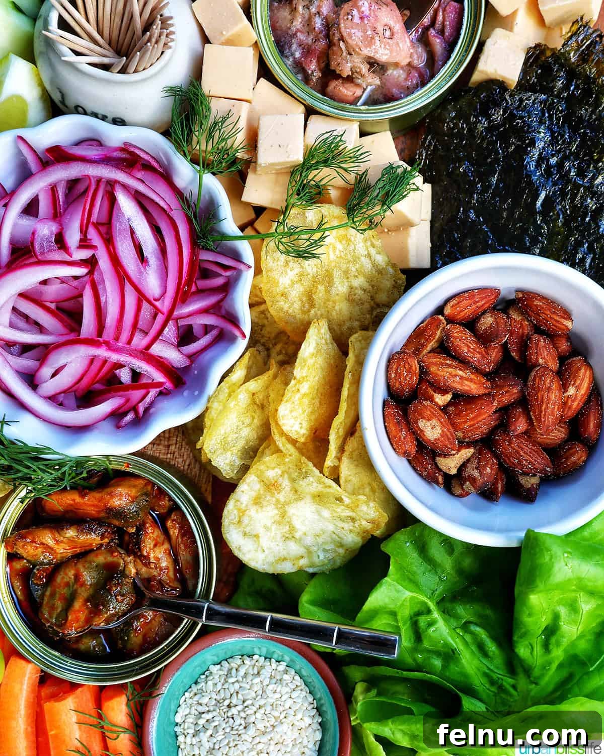 Overhead shot of a seacuterie board with an assortment of tinned fish, vibrant fruits, fresh vegetables, crispy chips, an array of crackers, and tasteful garnishes.