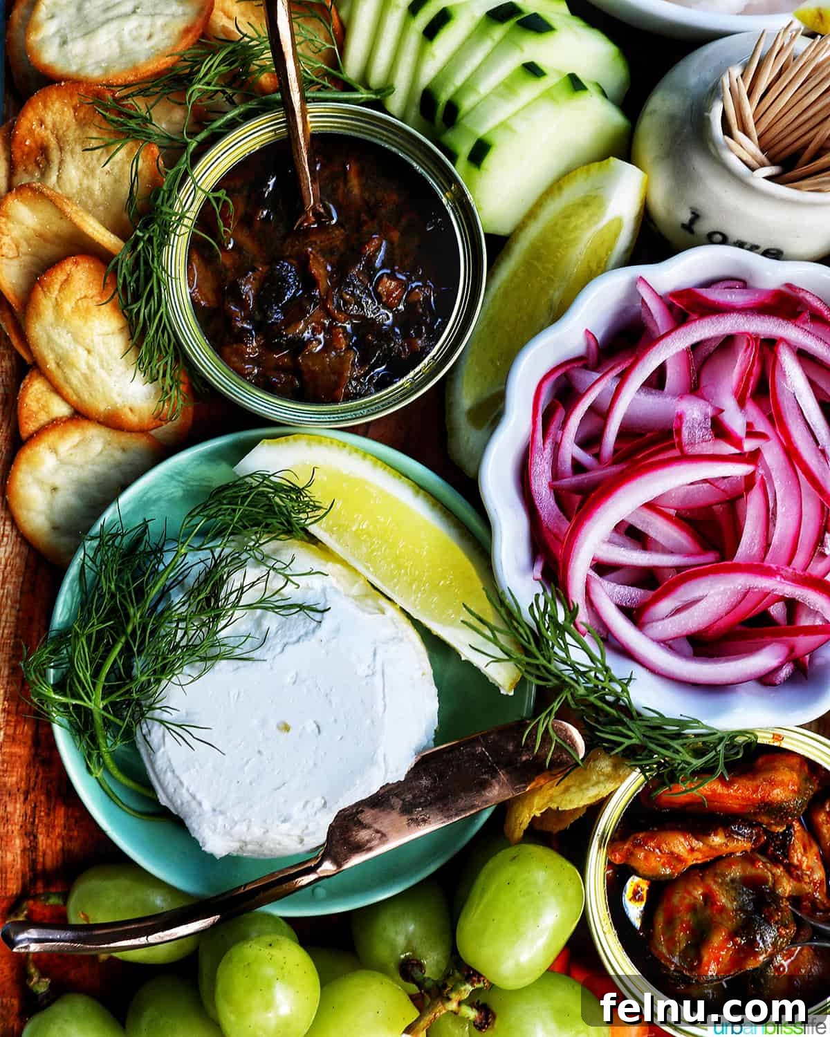 A beautifully arranged seacuterie board displaying tinned fish, colorful fruits, crisp vegetables, assorted chips and crackers, and complementary garnishes.