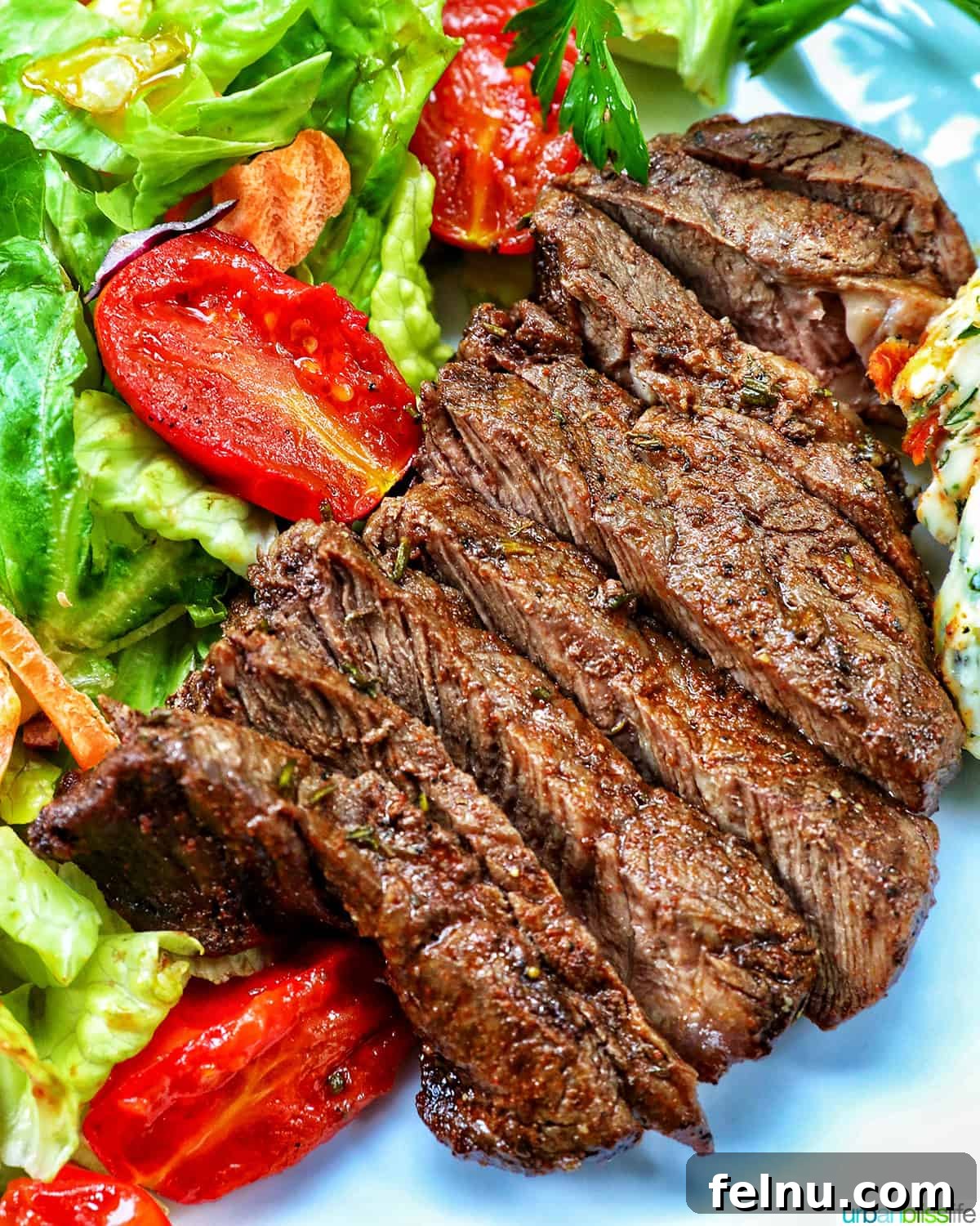 Air Fryer Filet Mignon Perfection 2 filet mignon sliced with a fresh green salad.
