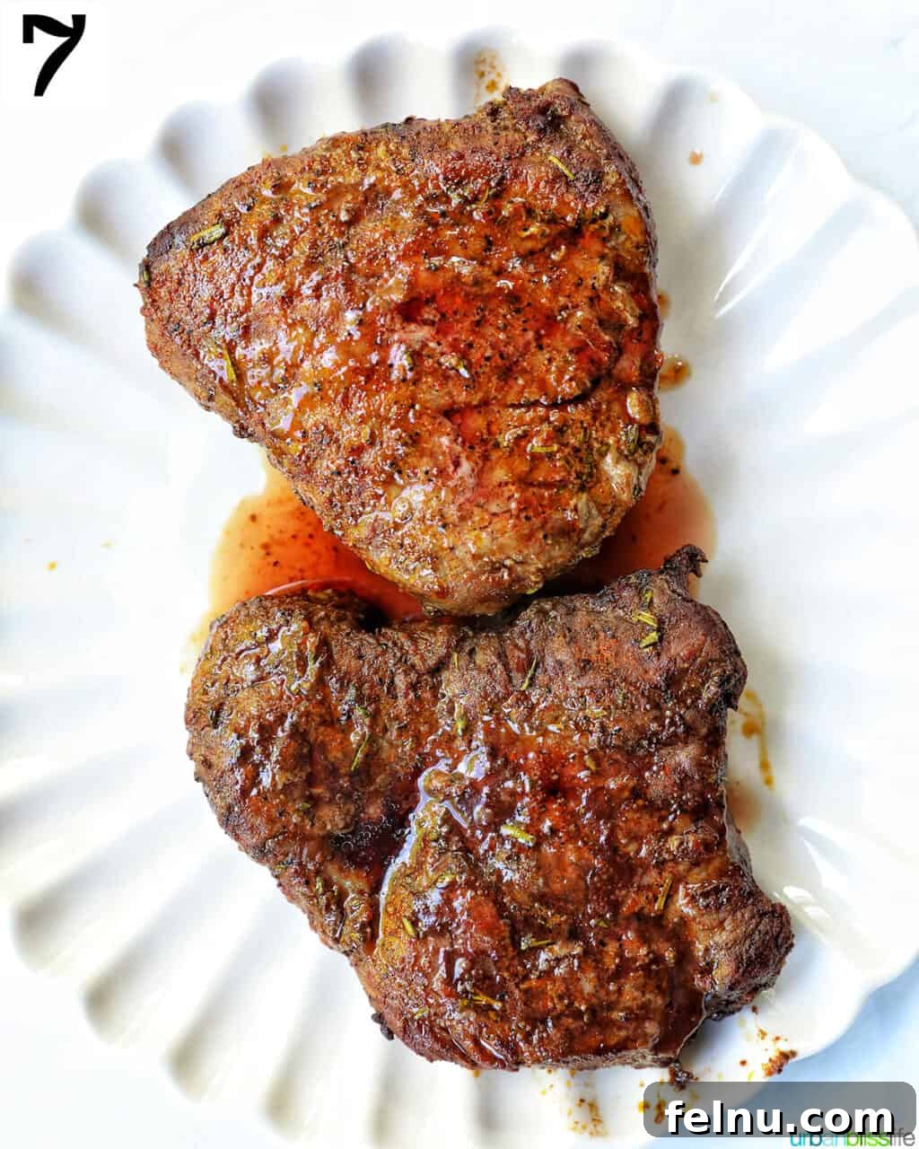 Air Fryer Filet Mignon Perfection 12 two perfectly cooked filet mignon steaks resting on a white plate, ready to be served.