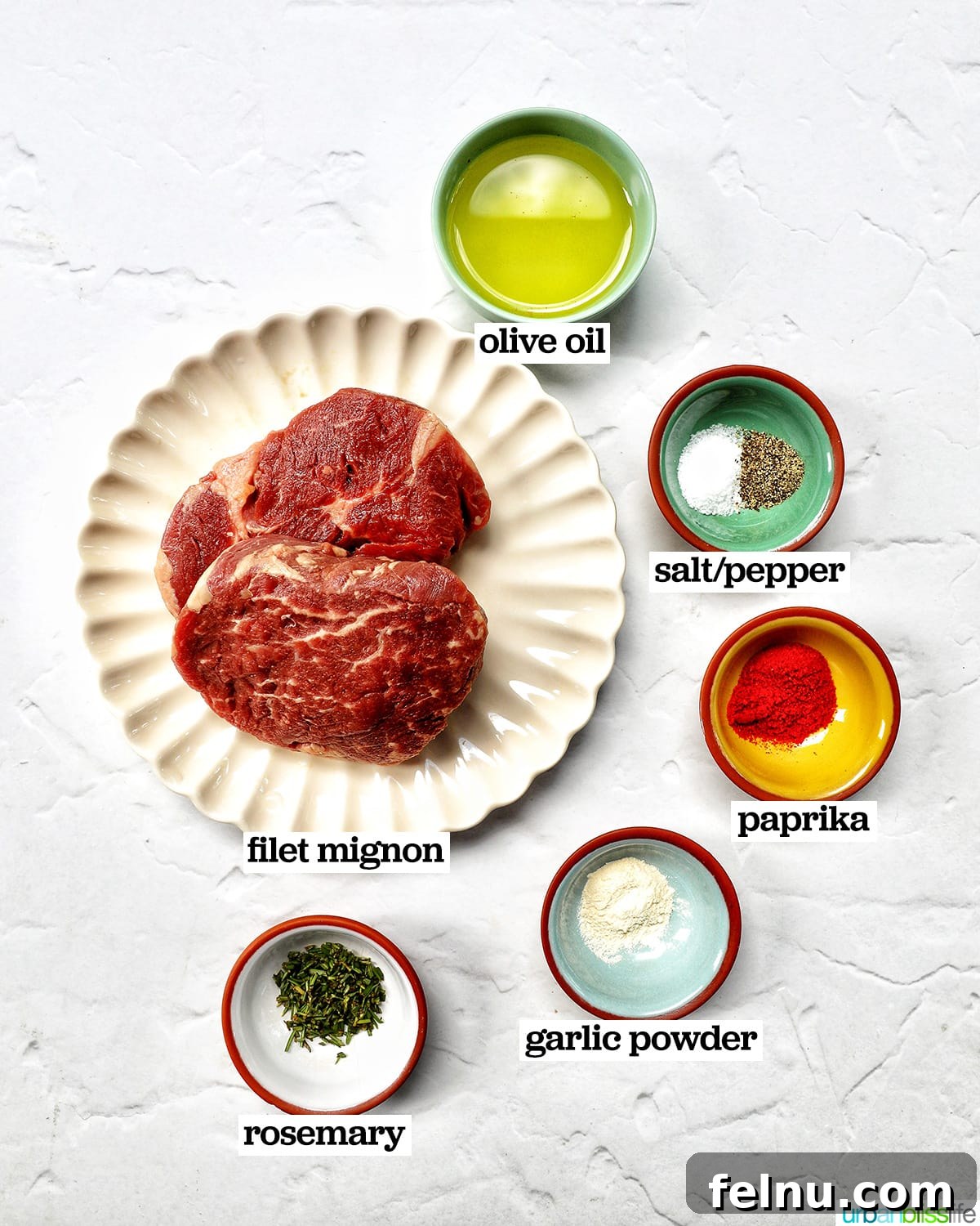 Air Fryer Filet Mignon Perfection 5 bowls of ingredients for air fryer filet mignon, including olive oil, fresh rosemary, garlic powder, paprika, salt, and pepper.