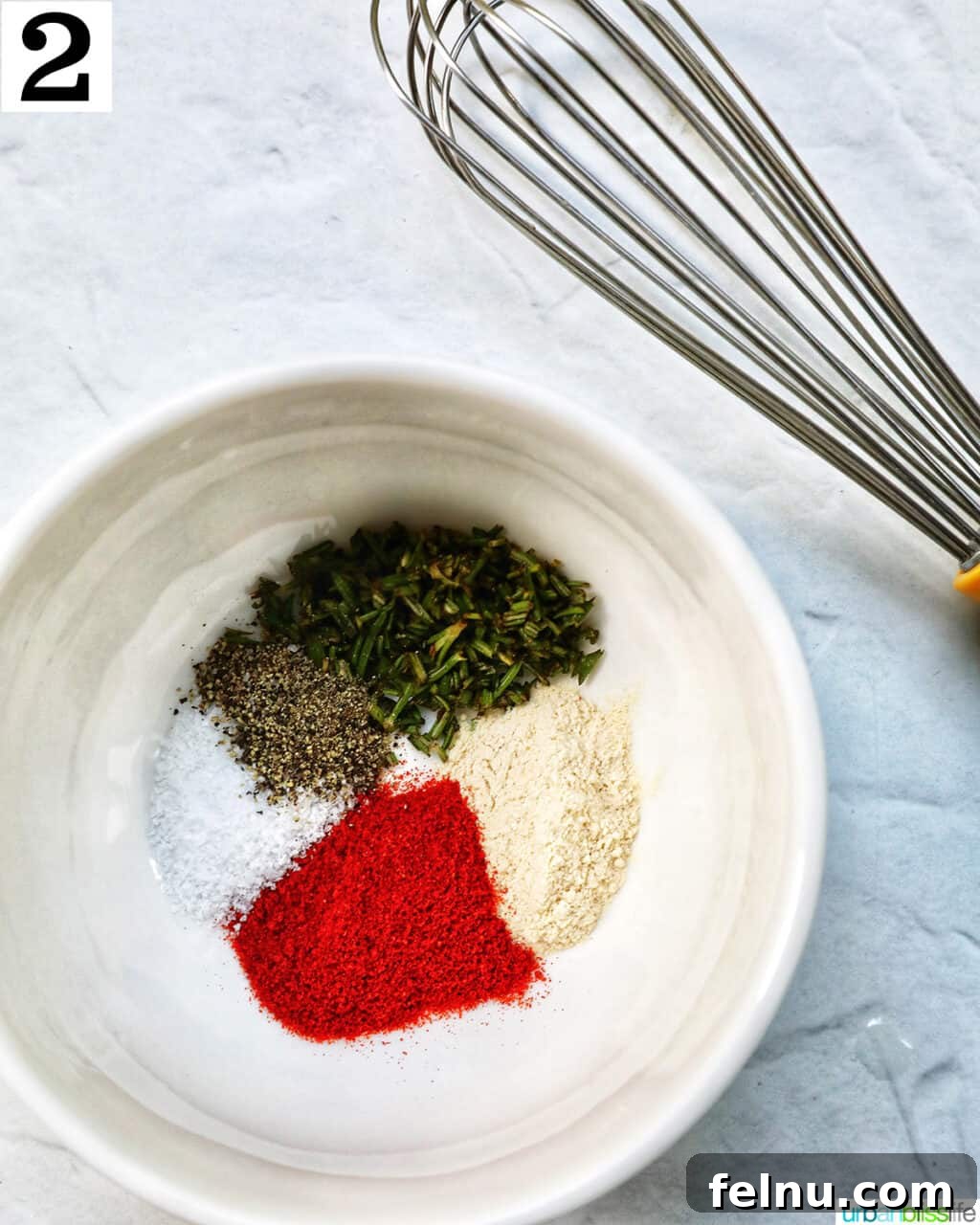 Air Fryer Filet Mignon Perfection 7 a whisk in a bowl of spices, showing the seasoning blend.