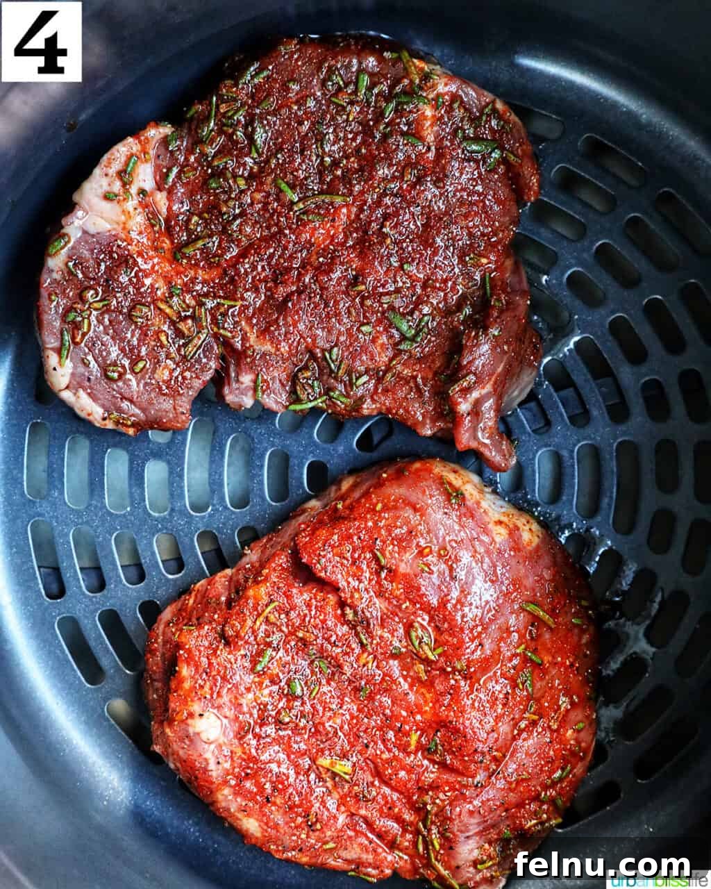 Air Fryer Filet Mignon Perfection 9 two raw seasoned filet mignon steaks placed neatly inside an air fryer basket.