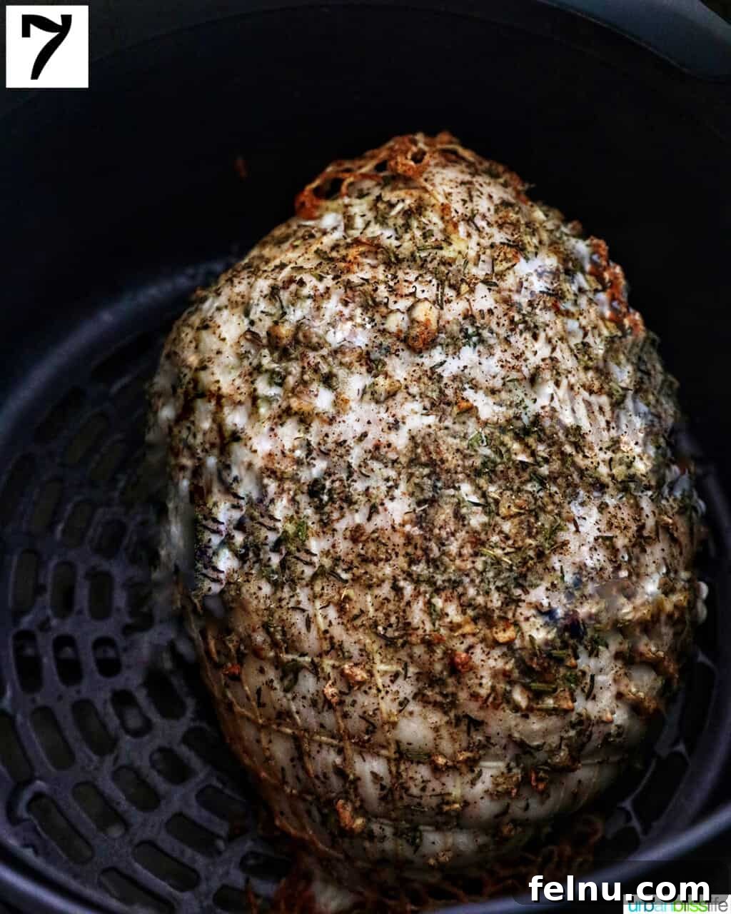 Crispy and Tender Air Fryer Turkey Breast 12 A perfectly cooked, golden-brown turkey breast resting in an air fryer basket after cooking.