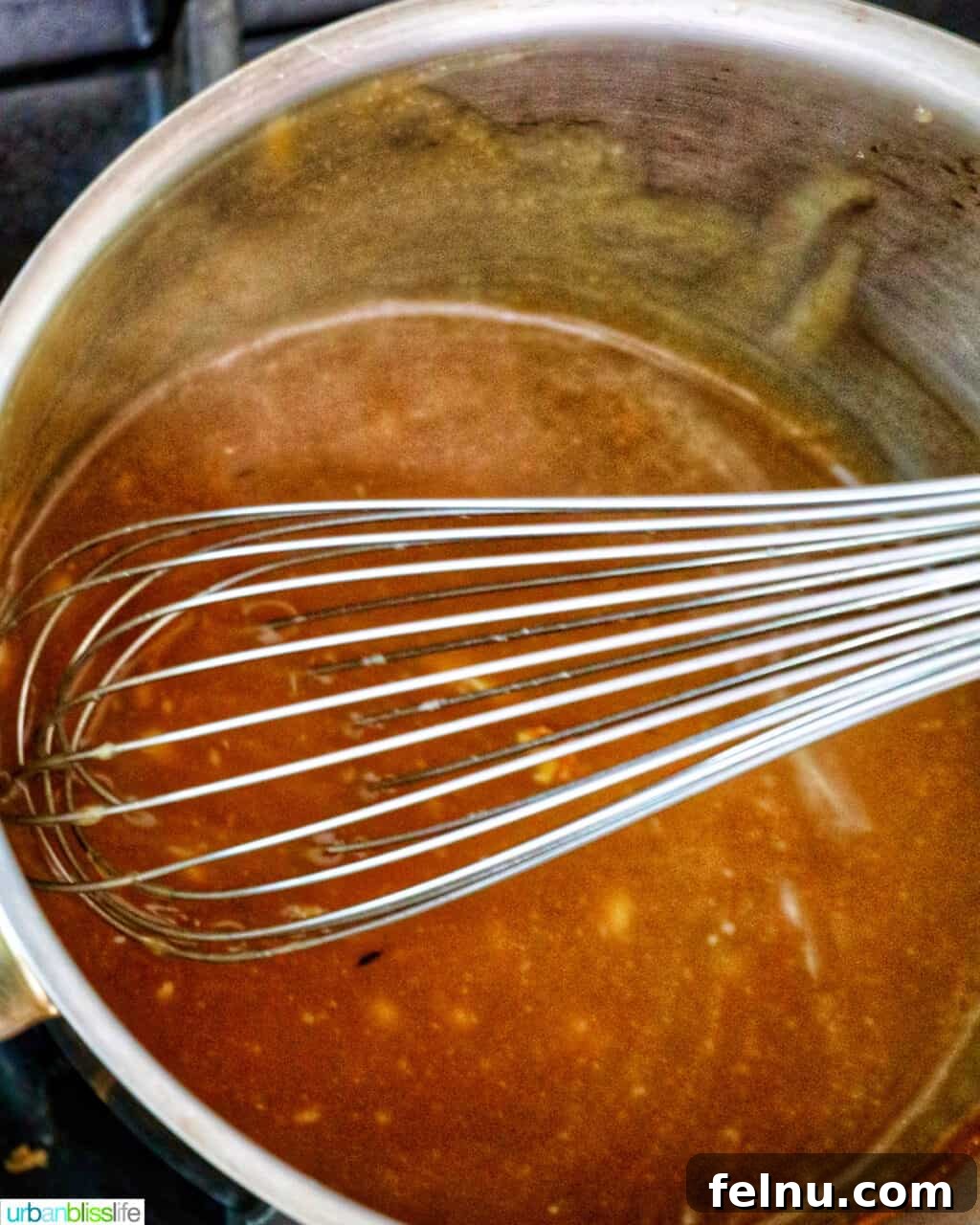 Crispy and Tender Air Fryer Turkey Breast 13 A whisk smoothly stirring rich gravy in a saucepan.