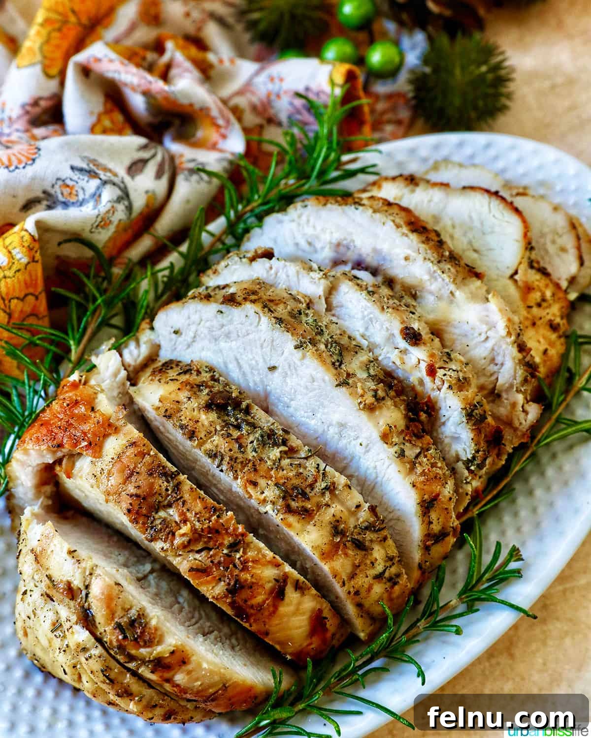 Crispy and Tender Air Fryer Turkey Breast 16 Artfully arranged slices of air fryer turkey breast, garnished with fresh rosemary sprigs on a serving plate.