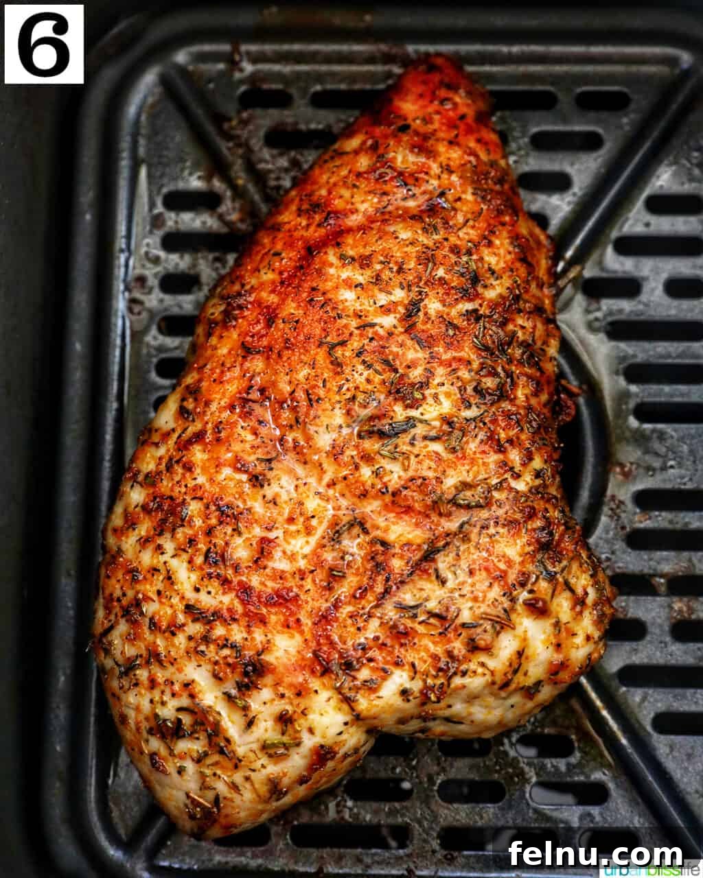 Perfect Air Fryer Turkey Tenderloin 11 Perfectly cooked turkey tenderloin resting in an air fryer basket after cooking.