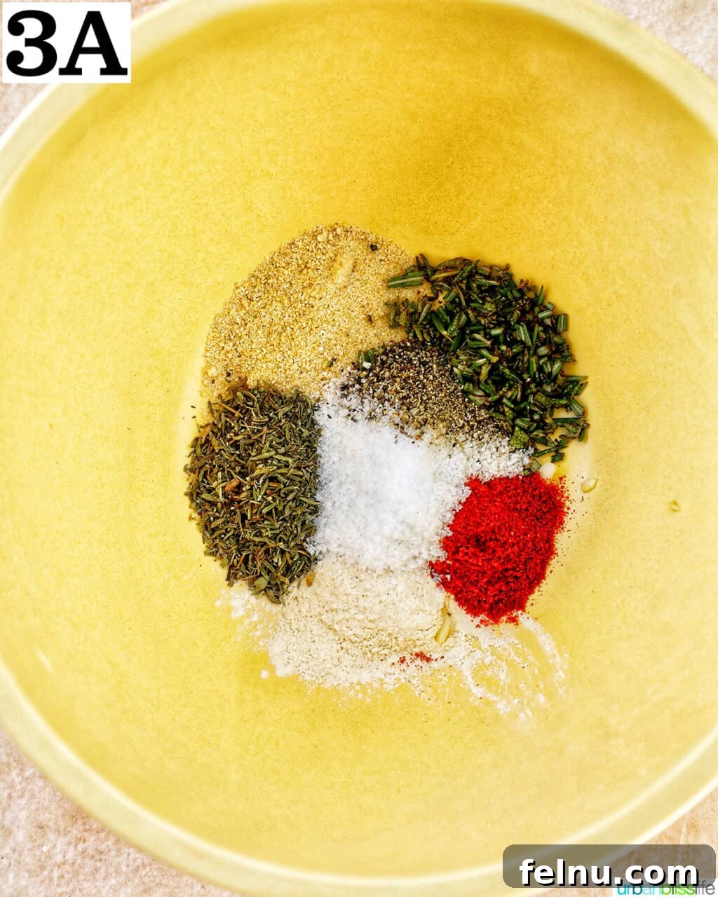Perfect Air Fryer Turkey Tenderloin 7 A small yellow bowl holding a vibrant mixture of various spices and seasonings.