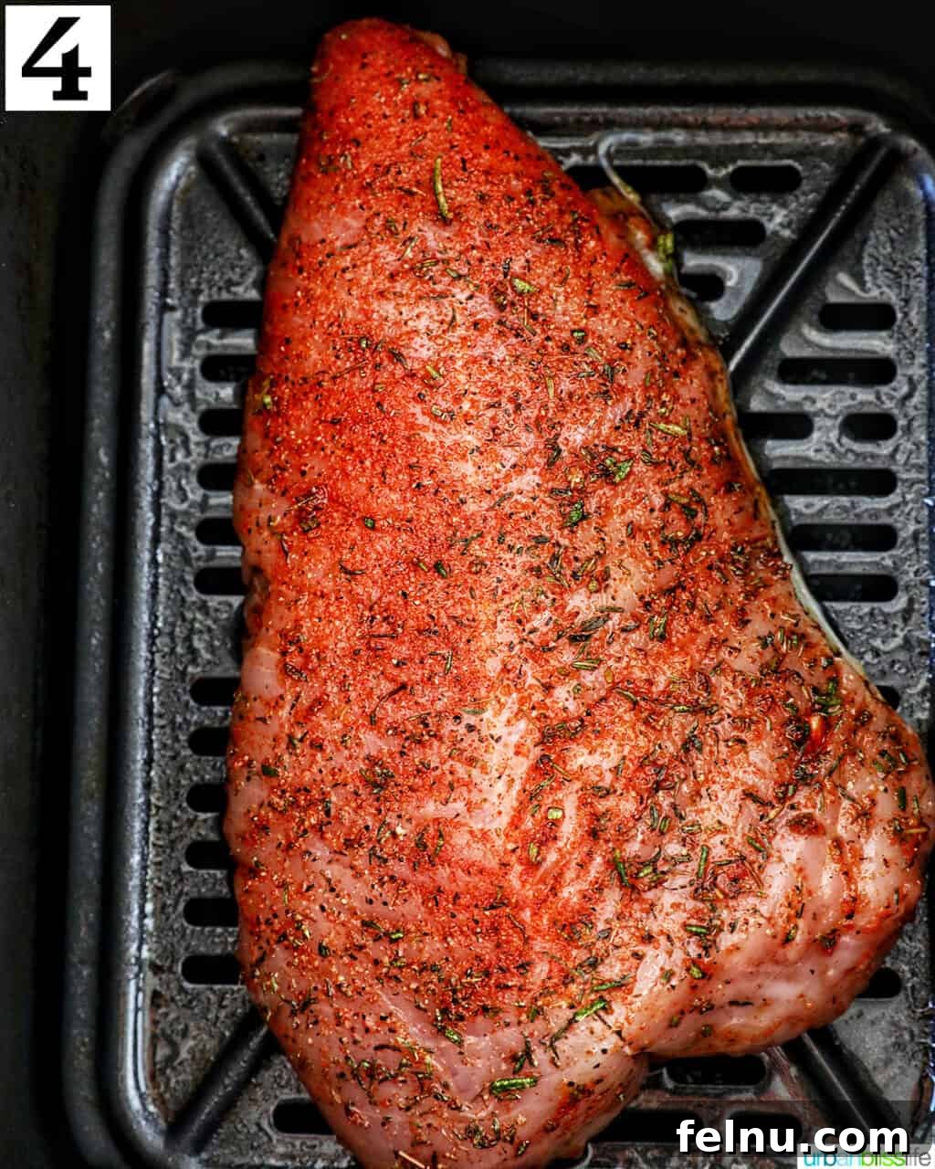 Perfect Air Fryer Turkey Tenderloin 9 A perfectly seasoned turkey tenderloin resting inside an air fryer basket, ready for cooking.