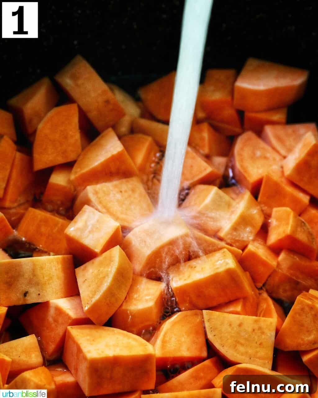 Silky Sweet Potato Puree 5 water pouring over a large pot of chopped sweet potatoes.