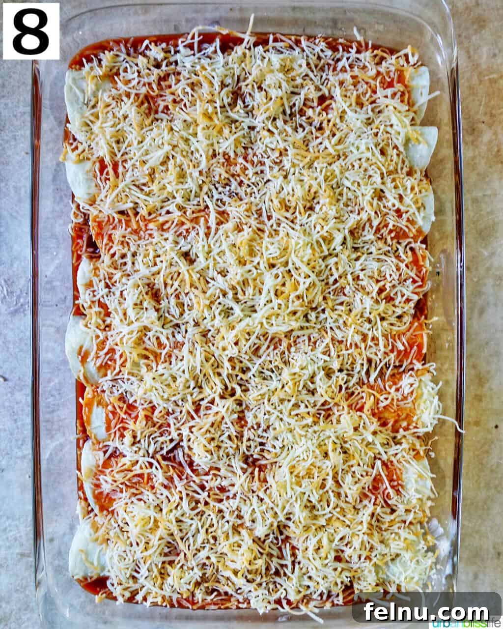 Delicious Leftover Turkey Enchilada Casserole 13 A generous layer of shredded cheese sprinkled over the sauced enchiladas in the casserole dish.