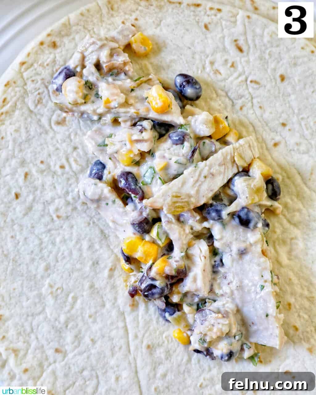 Delicious Leftover Turkey Enchilada Casserole 8 Enchilada filling placed in the center of a flour tortilla, ready to be rolled.
