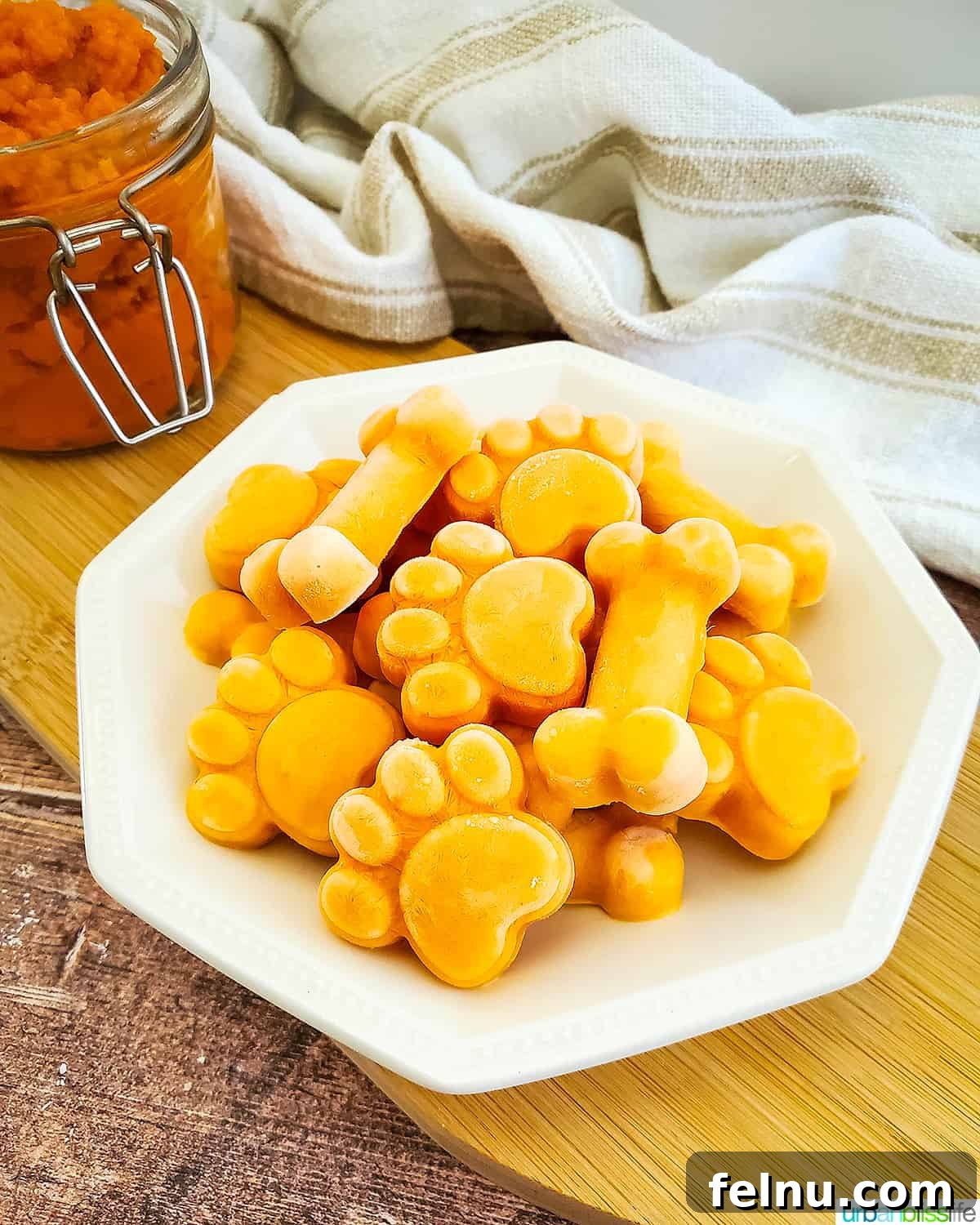 Easy Frozen Pumpkin Pupsicles 8 A full plate of various frozen pumpkin yogurt dog treats in different shapes, showcasing a generous batch.