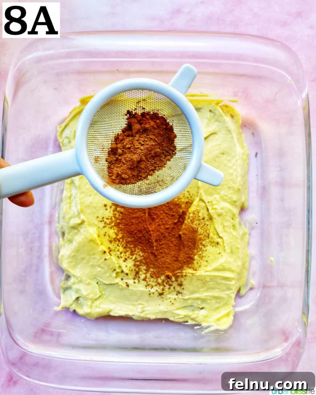 Decadent Dairy-Free Tiramisu 15 A generous dusting of cocoa powder being sieved over the creamy layer of the tiramisu.