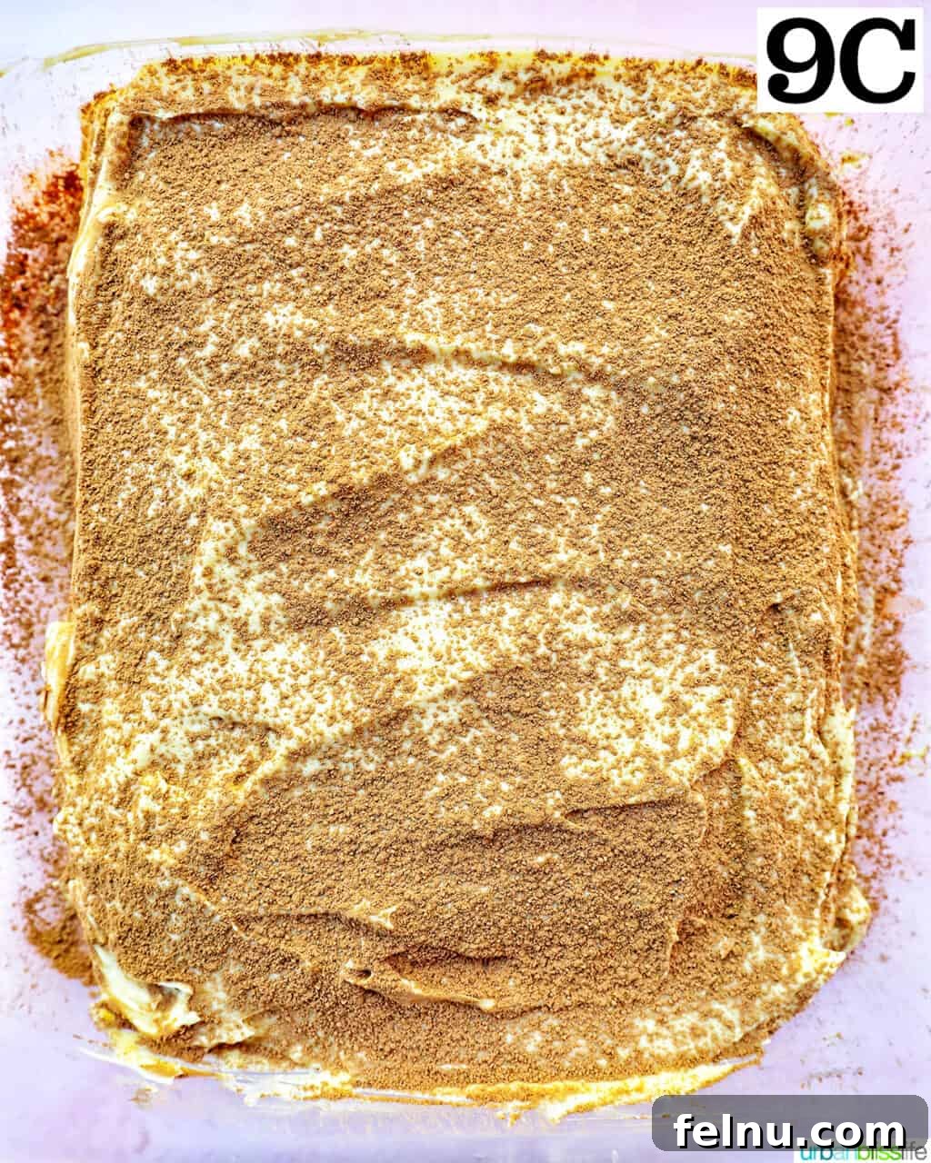 Decadent Dairy-Free Tiramisu 19 Dusting cocoa powder over the top of the second cream layer of the tiramisu, completing the core layers.