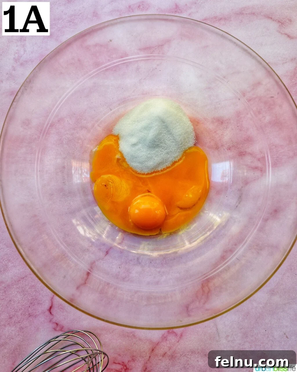 Decadent Dairy-Free Tiramisu 5 Egg yolks and granulated sugar waiting to be mixed in a clear glass bowl.