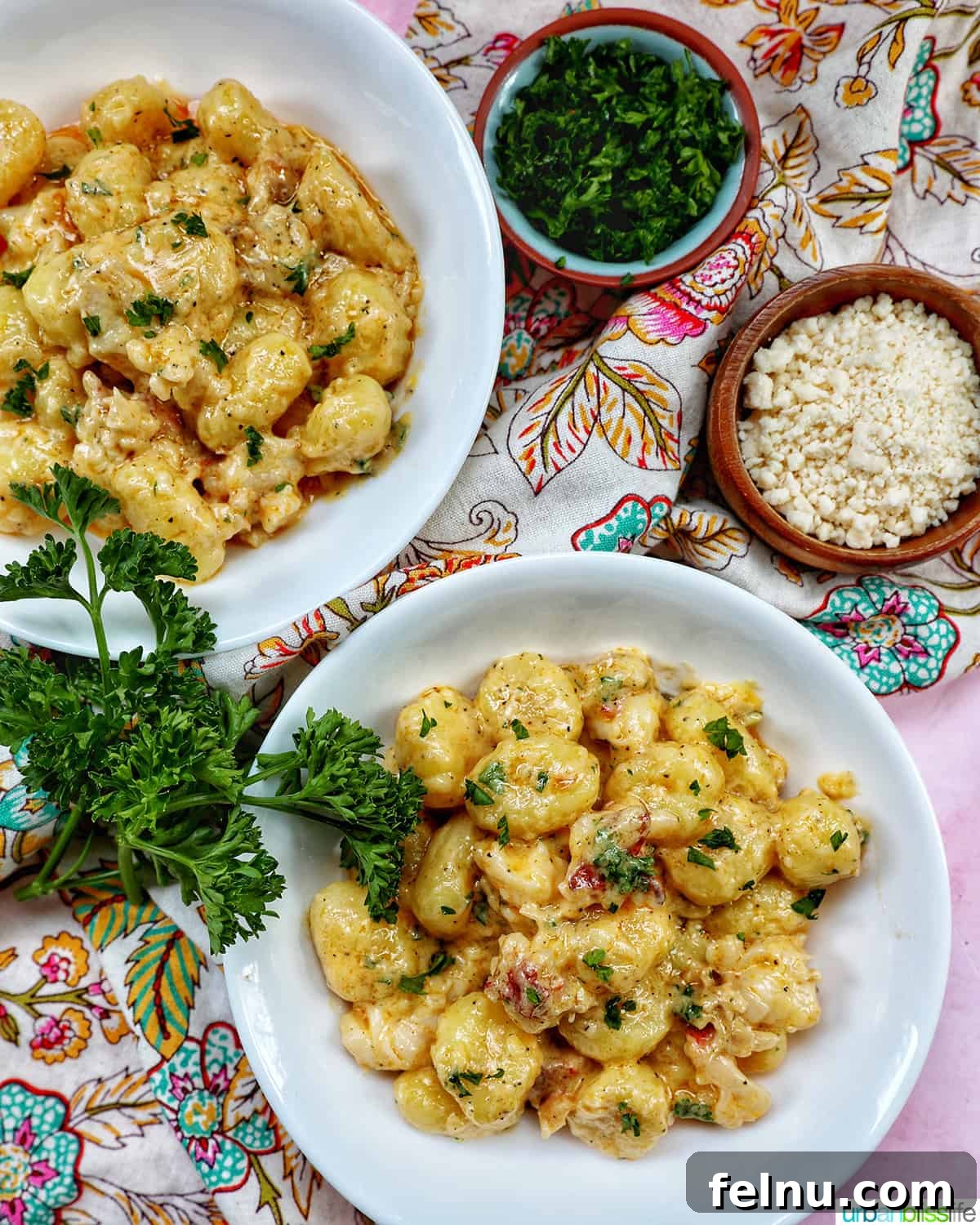 Decadent Lobster Gnocchi 3 Two bowls of creamy lobster gnocchi adorned with fresh herbs, with garnishes placed on the side, ready for a special dinner.