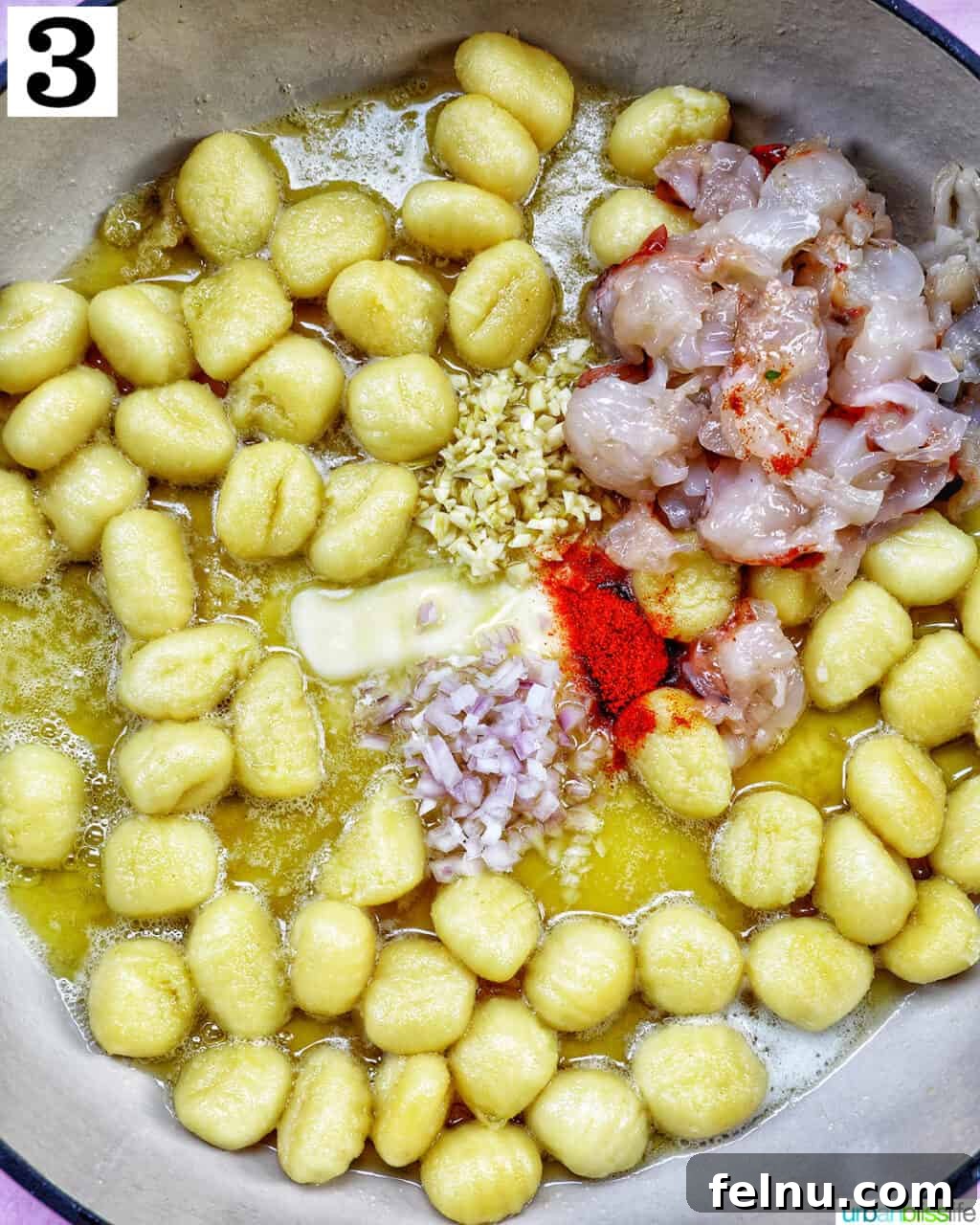 Decadent Lobster Gnocchi 7 Lobster pieces, garlic, shallots, and paprika cooking with gnocchi and butter in a skillet.