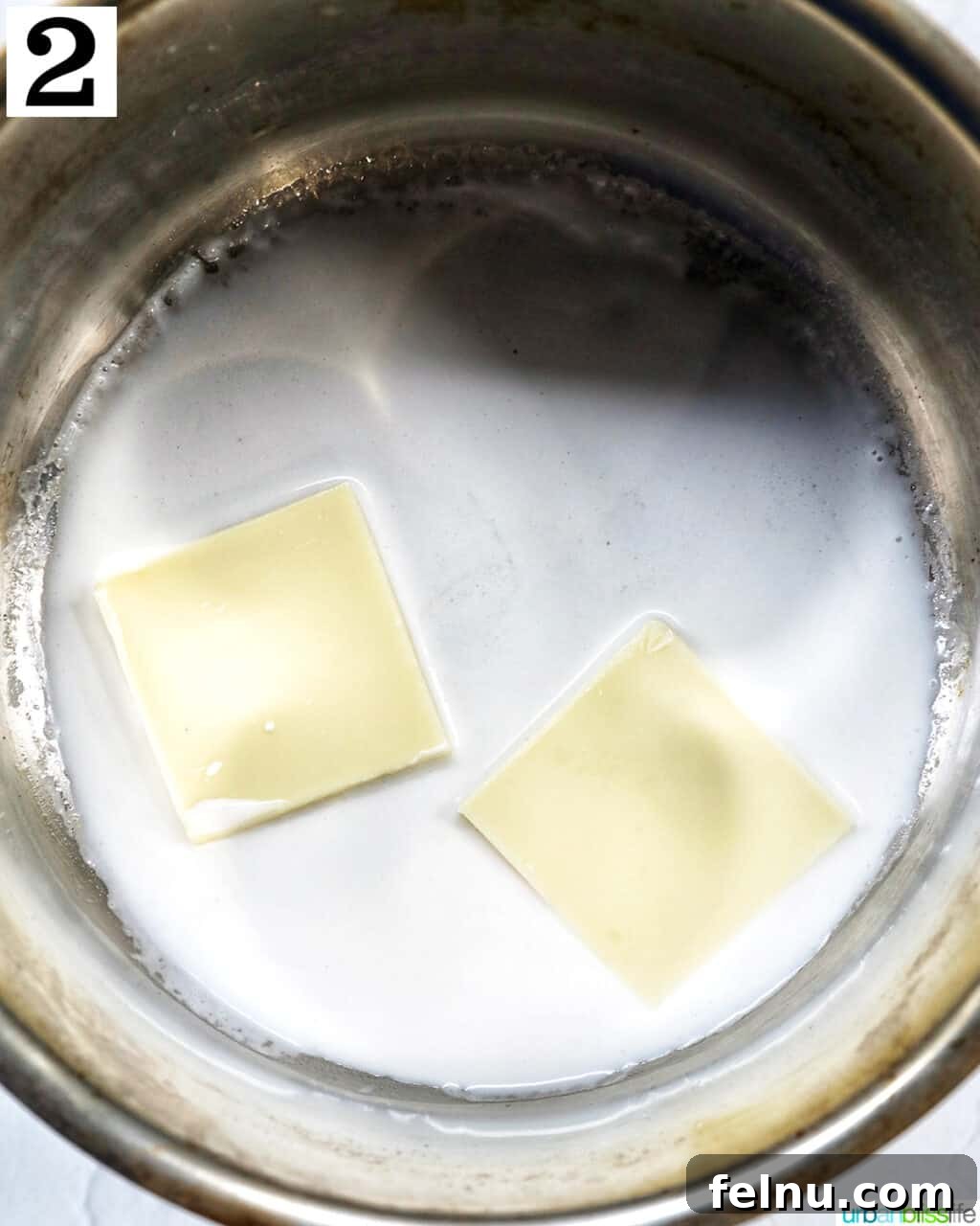 Adding white chocolate to the cream in a saucepan