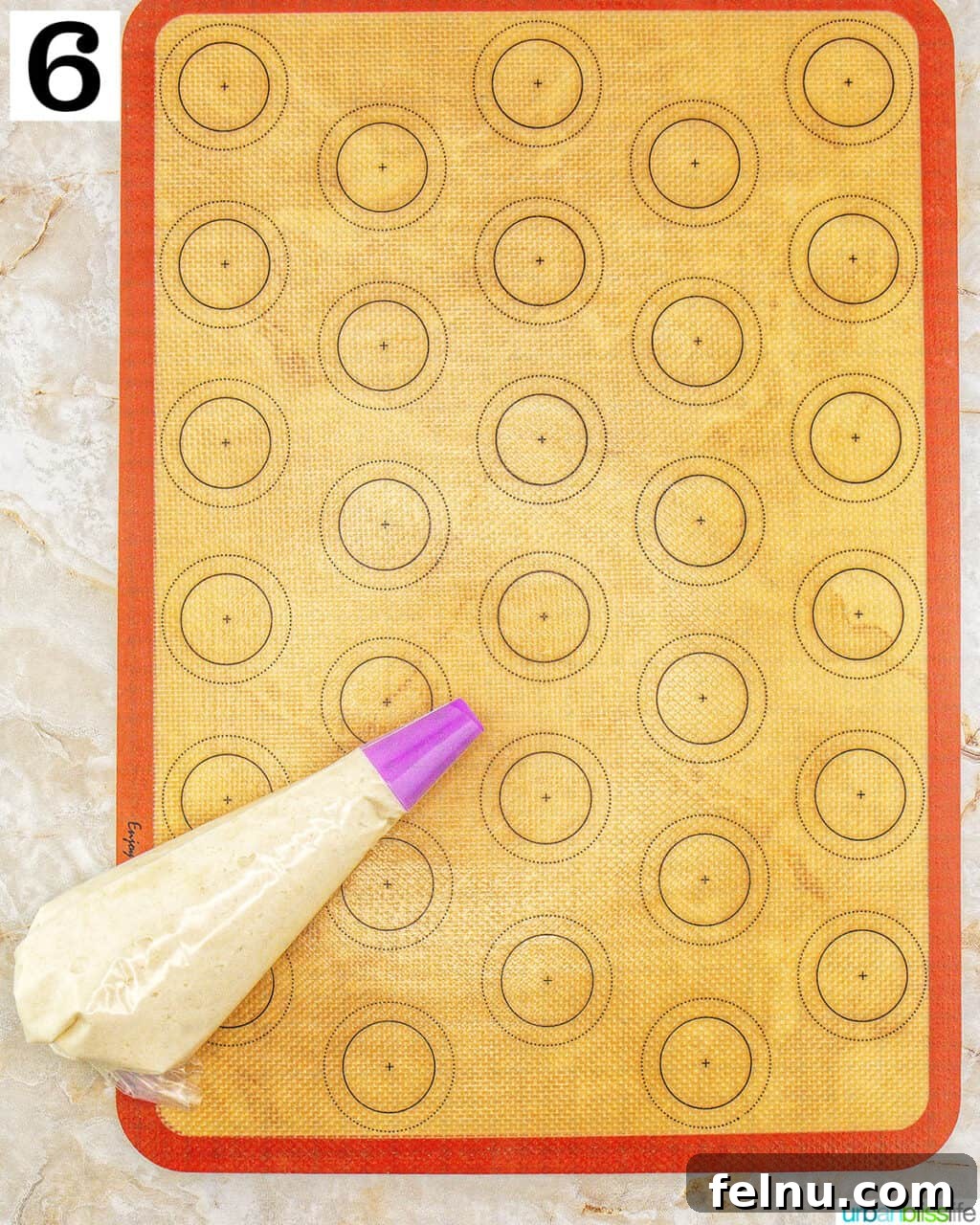 Espresso Mascarpone Macarons 13 Piping macaron batter onto a silicone macaron mat.