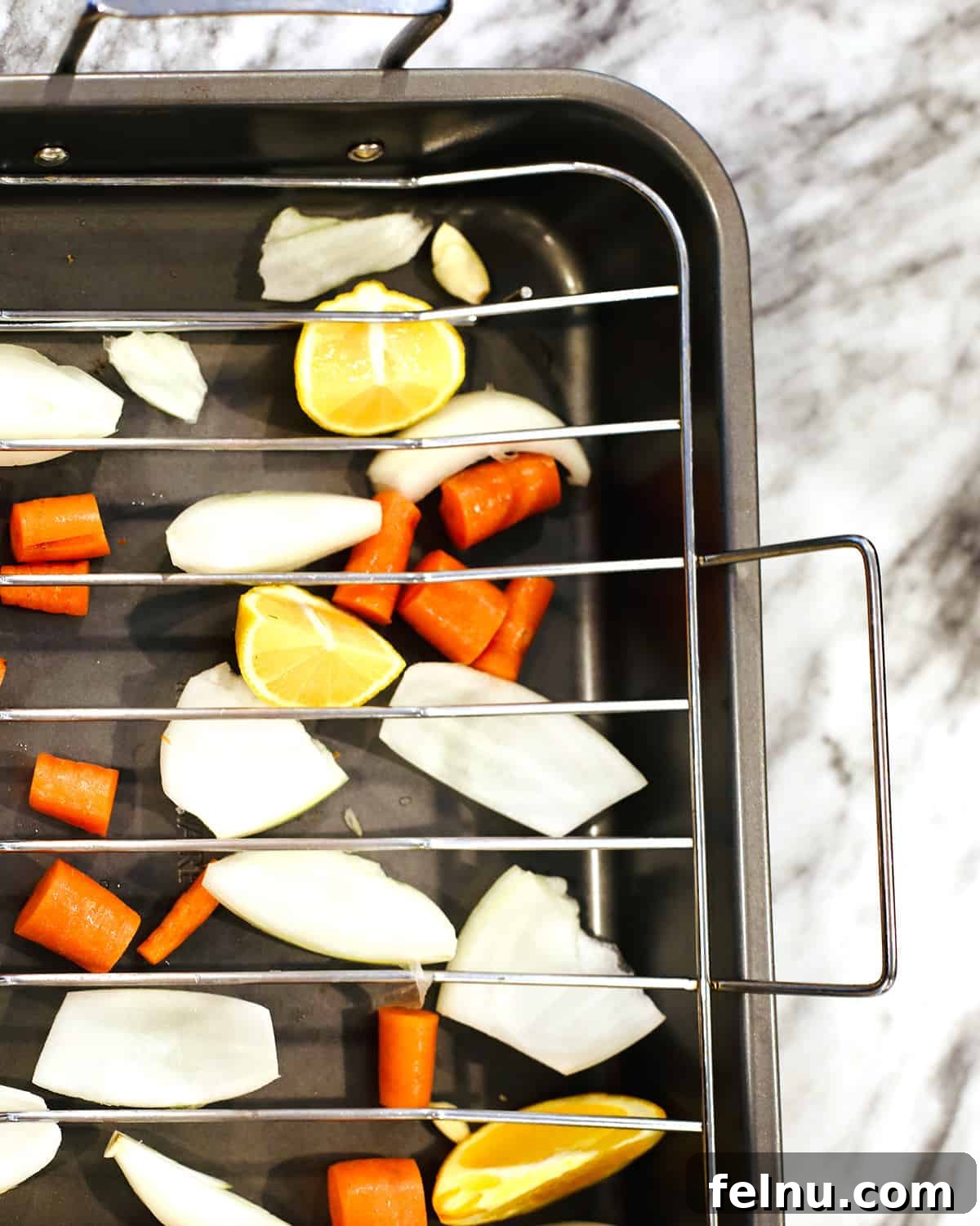 Your Stress-Free Thanksgiving Guide 5 chopped vegetables in a roasting pan with roasting rack.